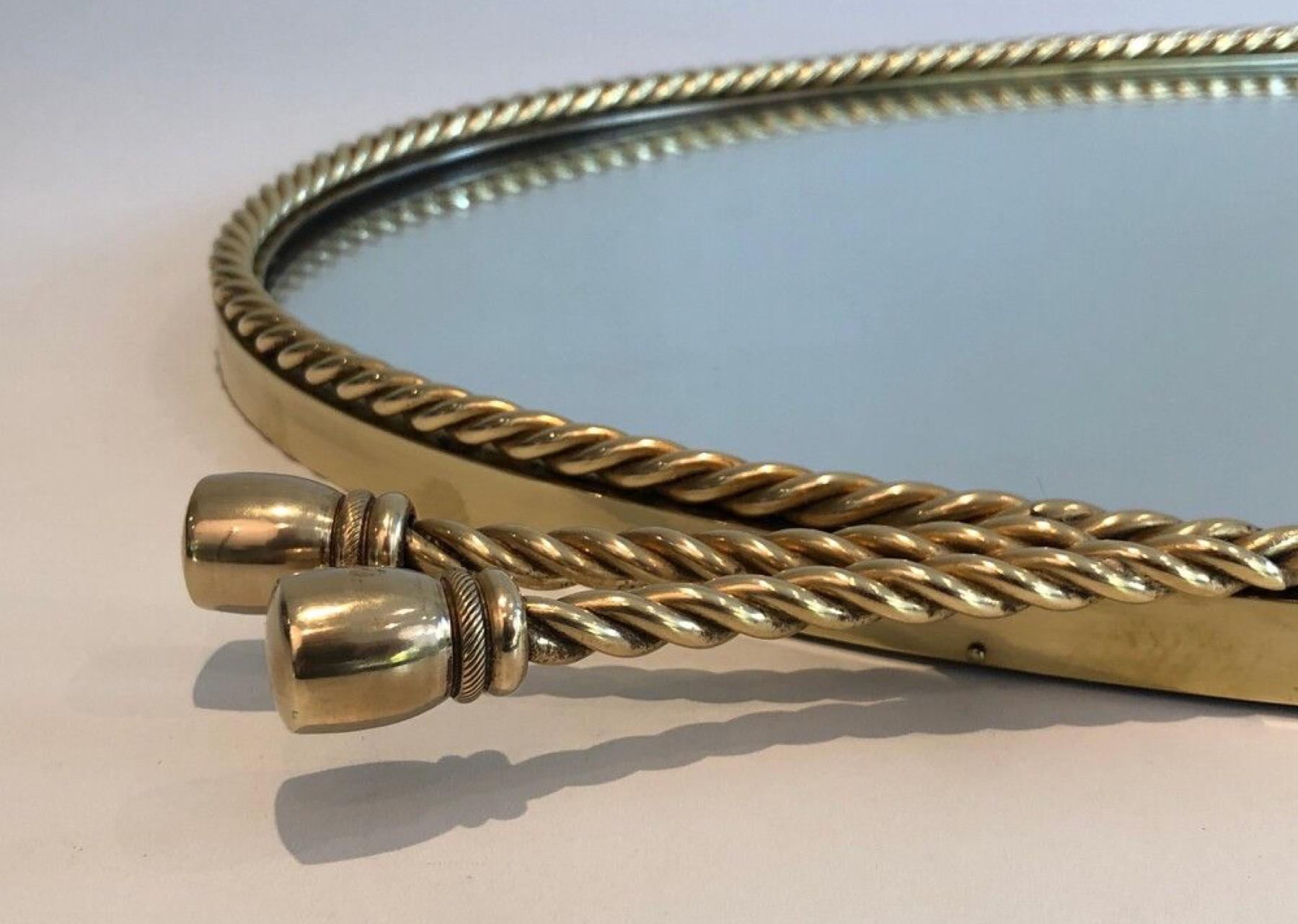 Espejo ovalado de latón rodeado de un cordón Al estilo de la Maison Bagués. Latón en venta