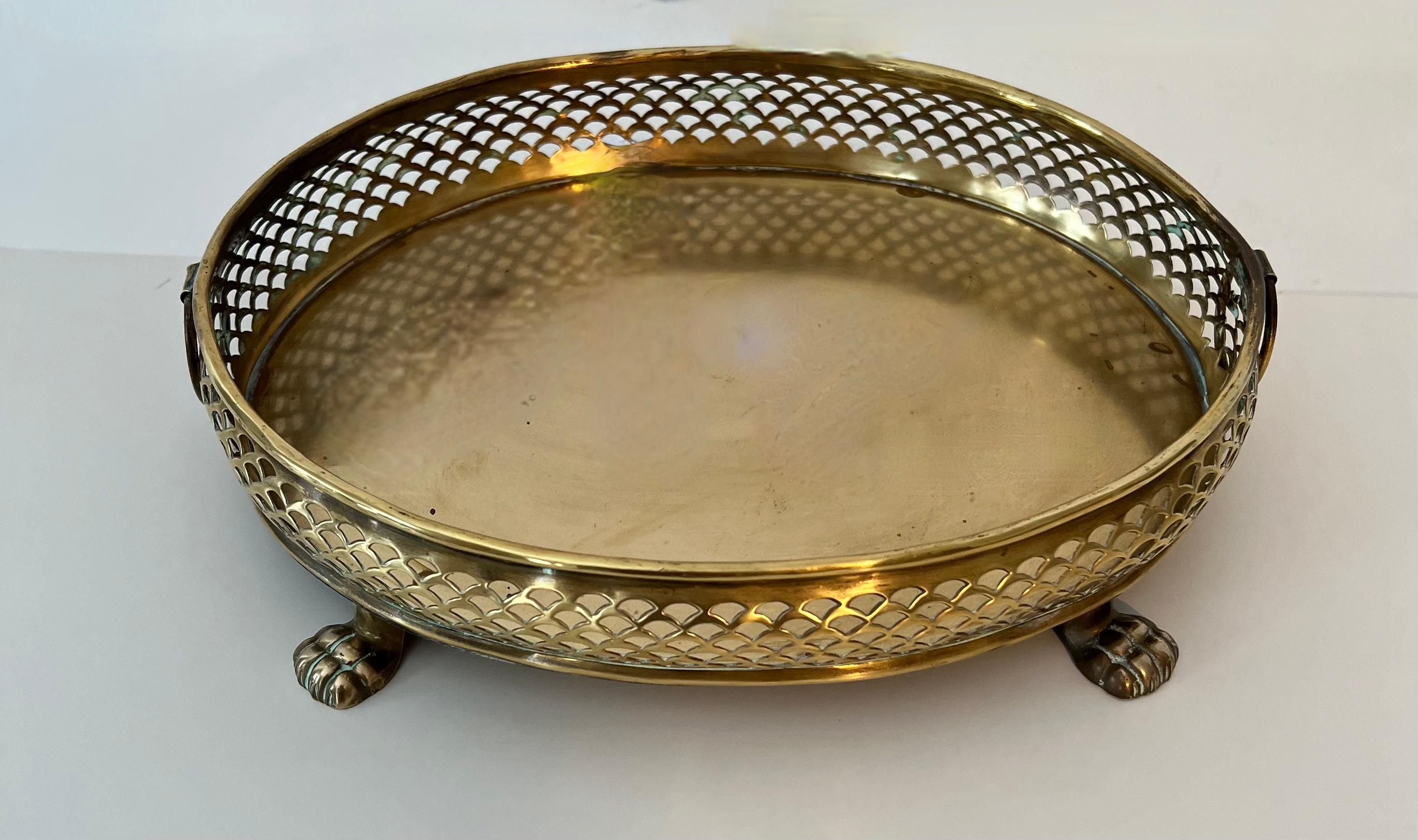 A lovely paw footed solid brass tray with a uniquely woven look gallery. The piece has decorative rings on the side. A compliment to any cocktail table of bar - while a great bar or dining room piece also would work well at a work station or on a