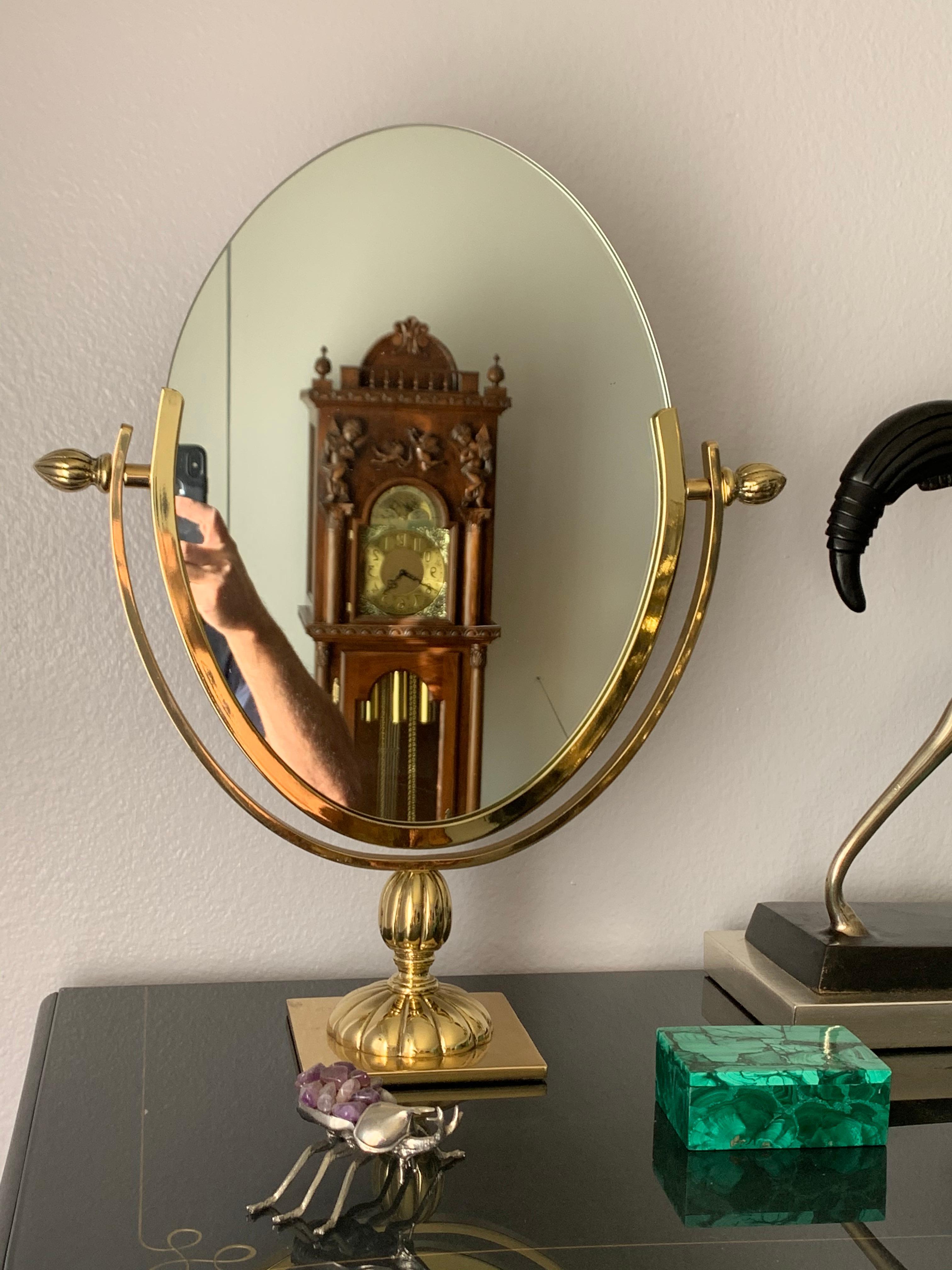 Oval brass vanity mirror in the style of Charles Hollis Jones. Mirror itself is 11