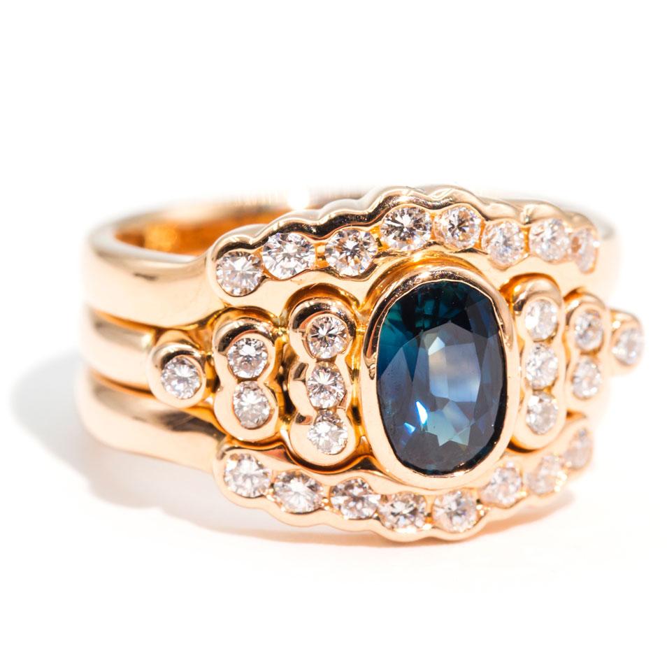 Carefully handmade in 18 carat rose gold is this glorious oval blue sapphire diamond ring.  She boasts a deep blue oval faceted natural sapphire surrounded by a plethora of sparkling white brilliant cut diamonds.  We have named this vintage