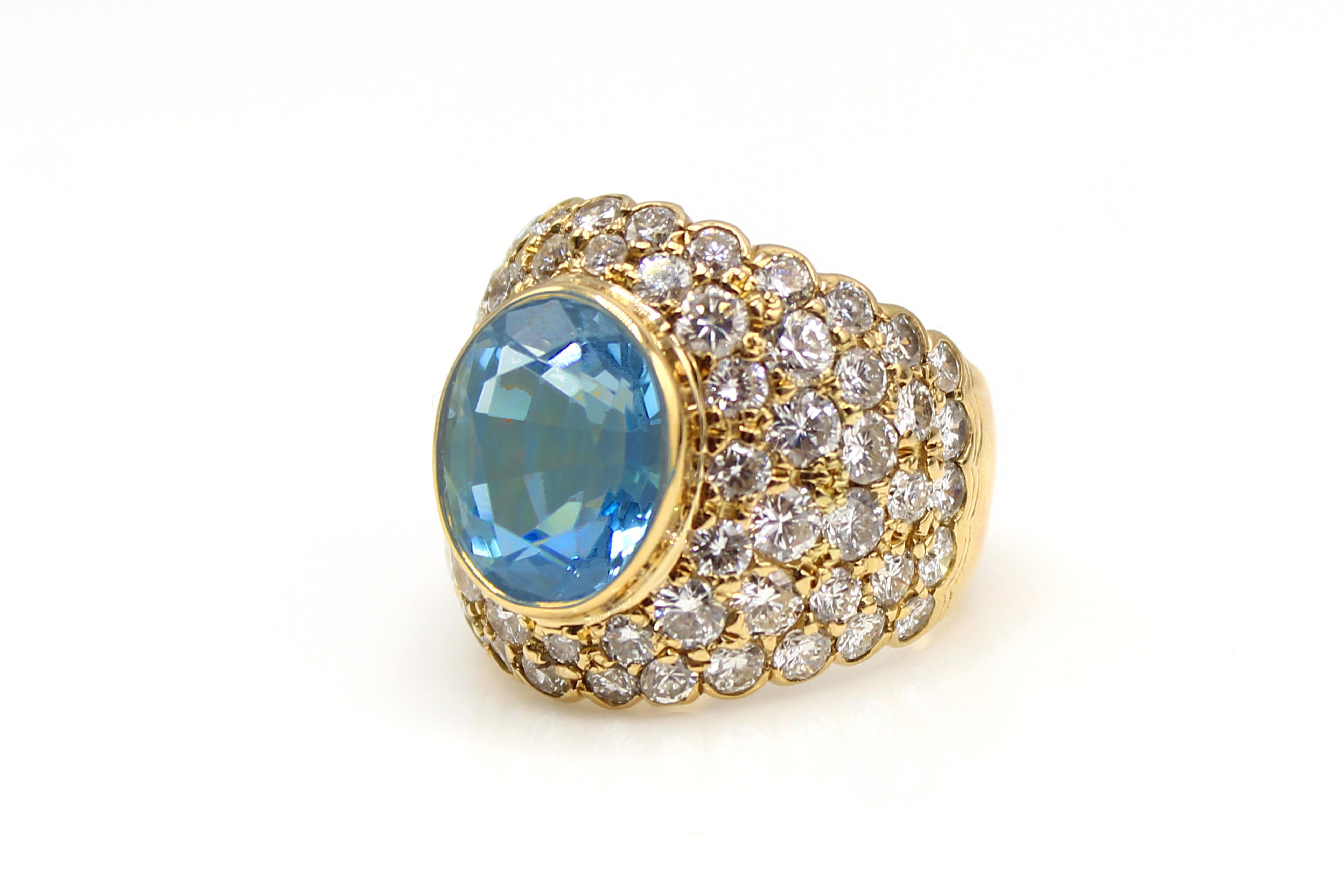 This uniquely designed, bold, and interesting ring from the 1980s was masterfully hand-crafted in 18-karat yellow gold. The wide half-band features a bezel-set Santa Maria color oval brilliant cut Aquamarine measured to weigh over 6 carats and has