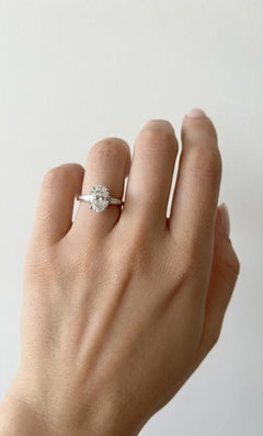 Oval Brilliant Cut Diamond and Tapered Baguette Three-Stone Engagement Ring