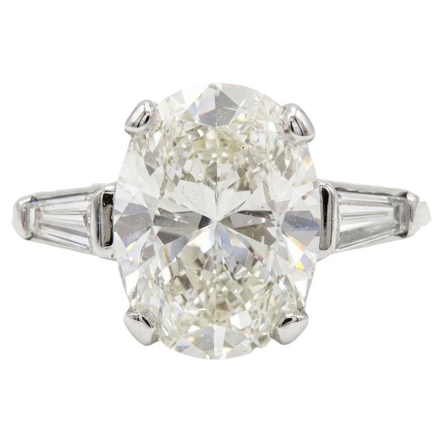 Oval Brilliant Cut Diamond and Tapered Baguette Three-Stone Engagement Ring For Sale