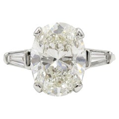 Oval Brilliant Cut Diamond and Tapered Baguette Three-Stone Engagement Ring