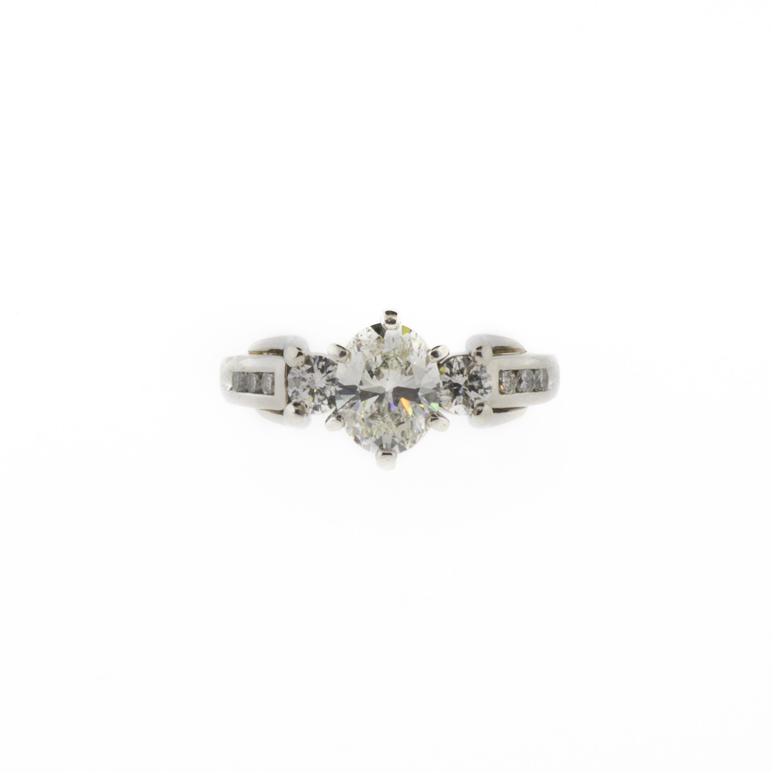 A one-of-a-kind vintage diamond engagement ring with a unique interlocking design detail in dazzling platinum. The main stone is a stunning GIA certified 1.07ct oval brilliant cut H/SI1 natural diamond, surrounded by .39ctw of various sizes of round