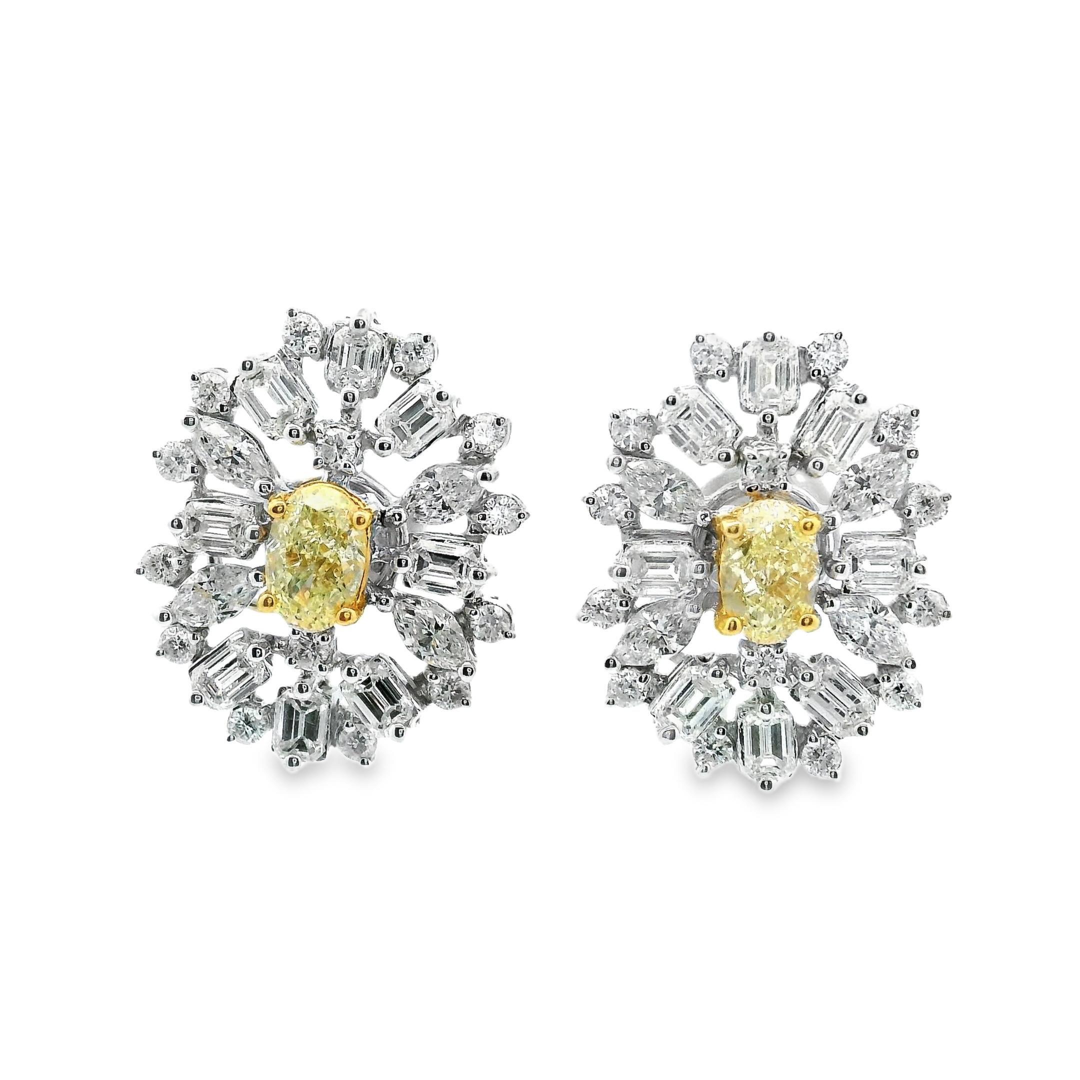 Un paio di importanti orecchini di diamanti in stile Winston, splendidamente disegnati e magistralmente lavorati a mano in oro bianco 18 carati, con due livelli di diamanti incastonati. La pietra centrale, un diamante giallo Nature Fancy dal taglio