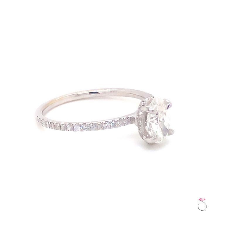 Élégante bague de fiançailles à diamant avec halo caché en or blanc 18 carats, comprenant un diamant ovale de taille brillant de 0,71 carat, de couleur F et de pureté VS1, avec rapport GIA.  Le diamant est serti dans quatre griffes françaises avec