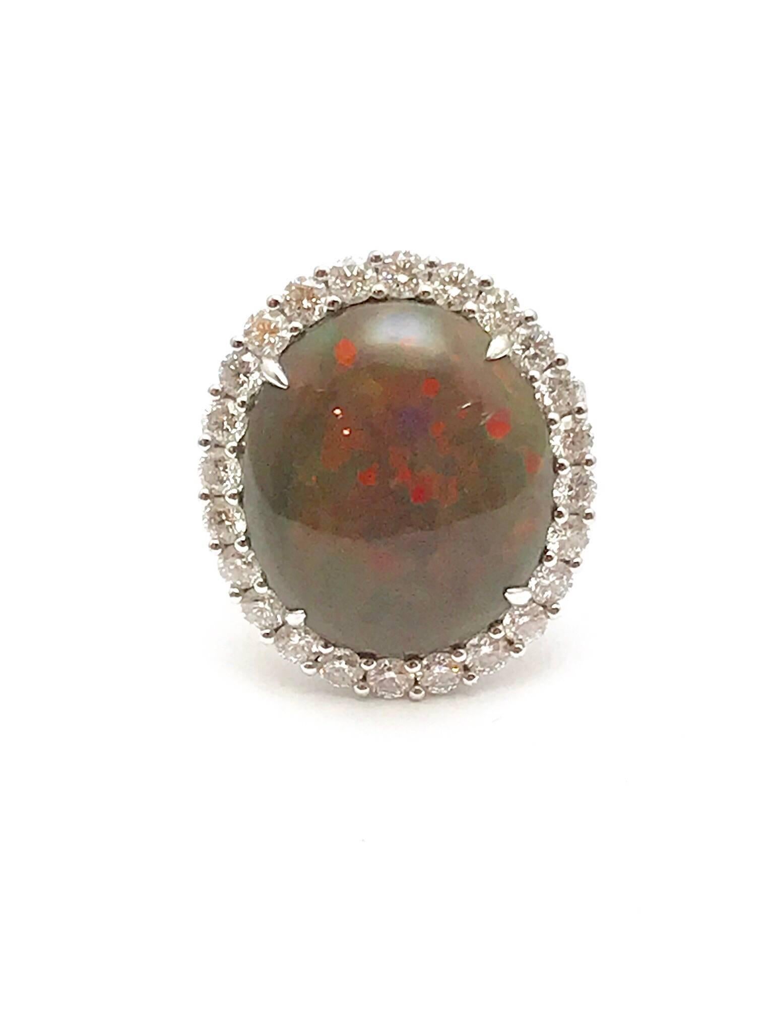An oval cabochon boulder opal and round brilliant diamond 18 karat white gold ring.  The opal is set with four prongs, framed by a single row of round brilliant diamonds.  The opal measures 17.00 x 15.00mm, and displays a beautiful array of colors. 