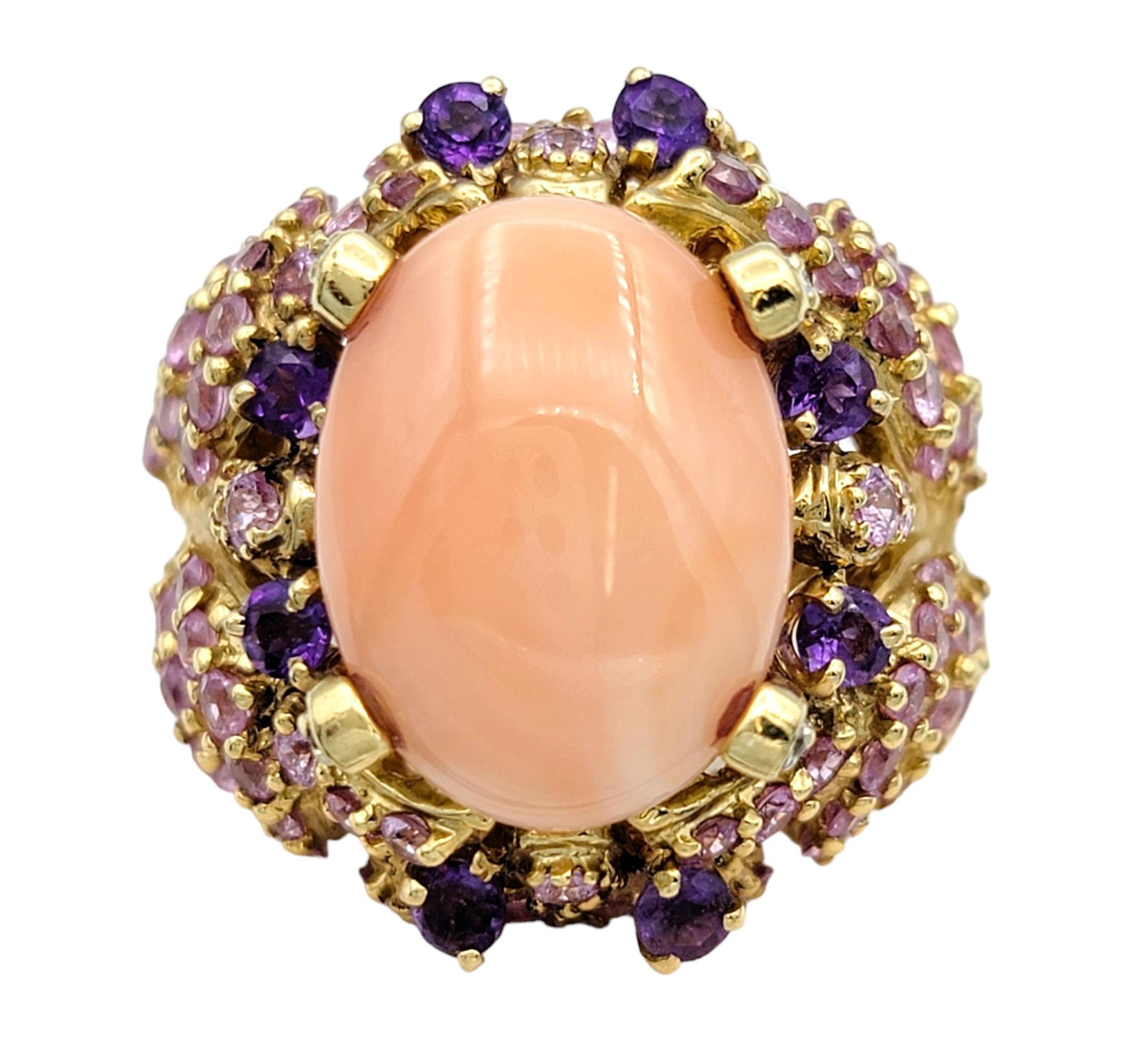 Ring Size: 7.5

This gorgeous cocktail ring, resplendent in lustrous 14 karat yellow gold, is a captivating statement piece that exudes elegance and charm. At its heart lies an exquisite oval coral cabochon, radiating with natural beauty and warmth.