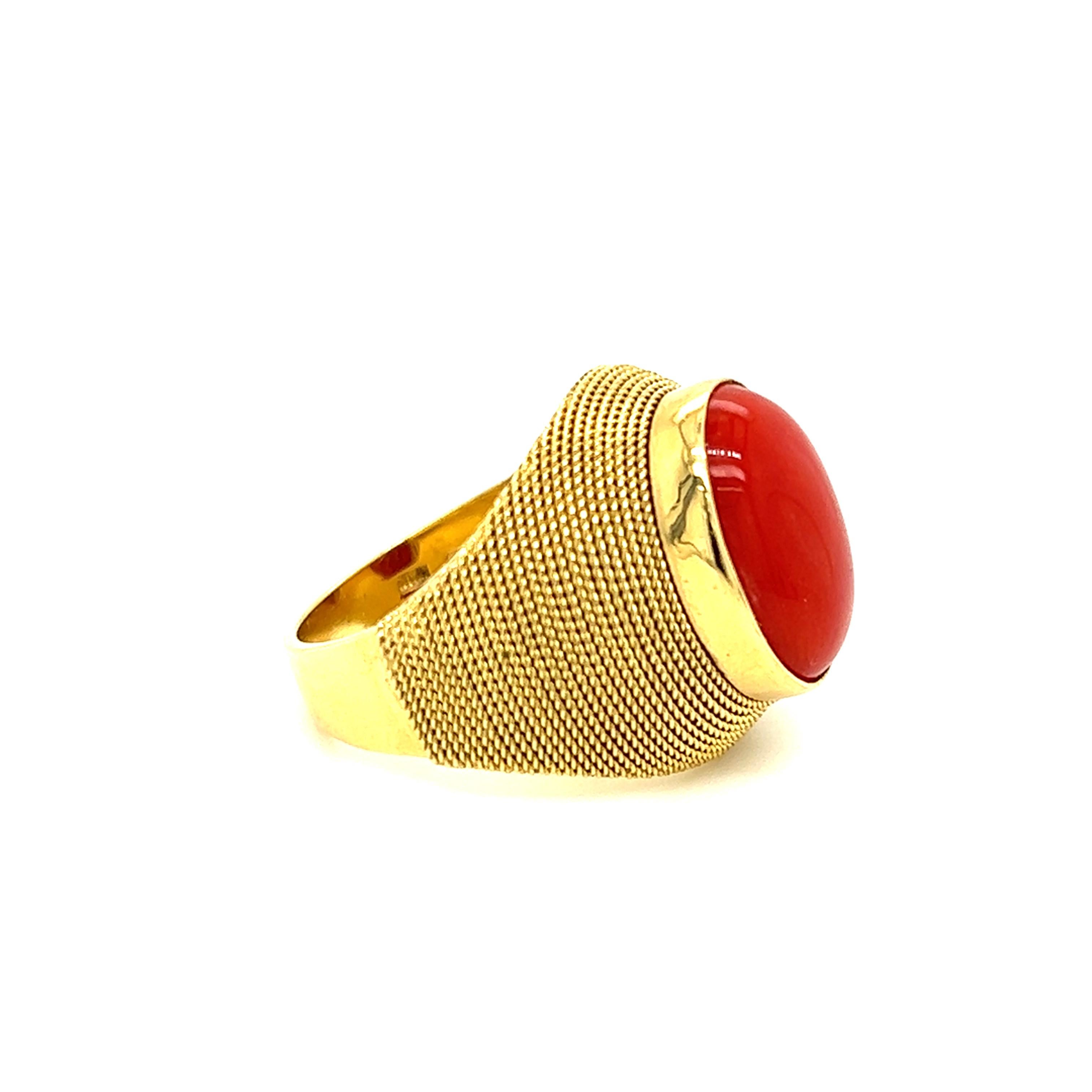 One 18-karat yellow gold rope ring, set with one 14x11mm oval cabochon coral stone.  The ring is a finger size 6.5 and weighs 9.5 grams in total weight.  The ring is resizable. Sizing is not included. 