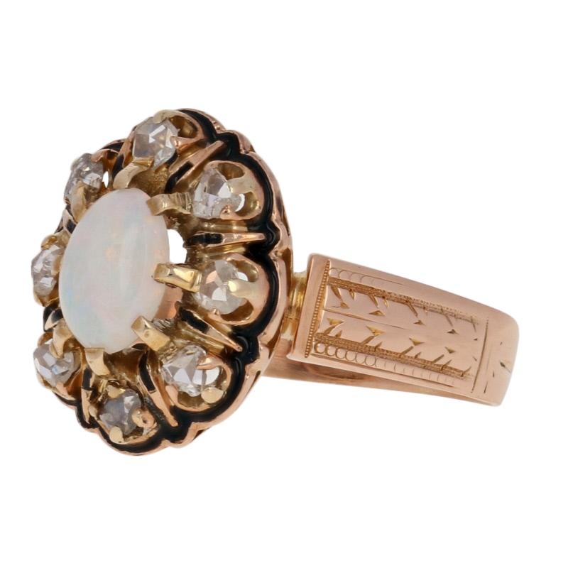 Add a touch of Victorian elegance to your modern wardrobe with this stunning piece! Crafted in 14k rose gold, this antique floral halo ring showcases a heavenly opal solitaire surrounded by rose cut white diamonds and rich black enameling. 

This