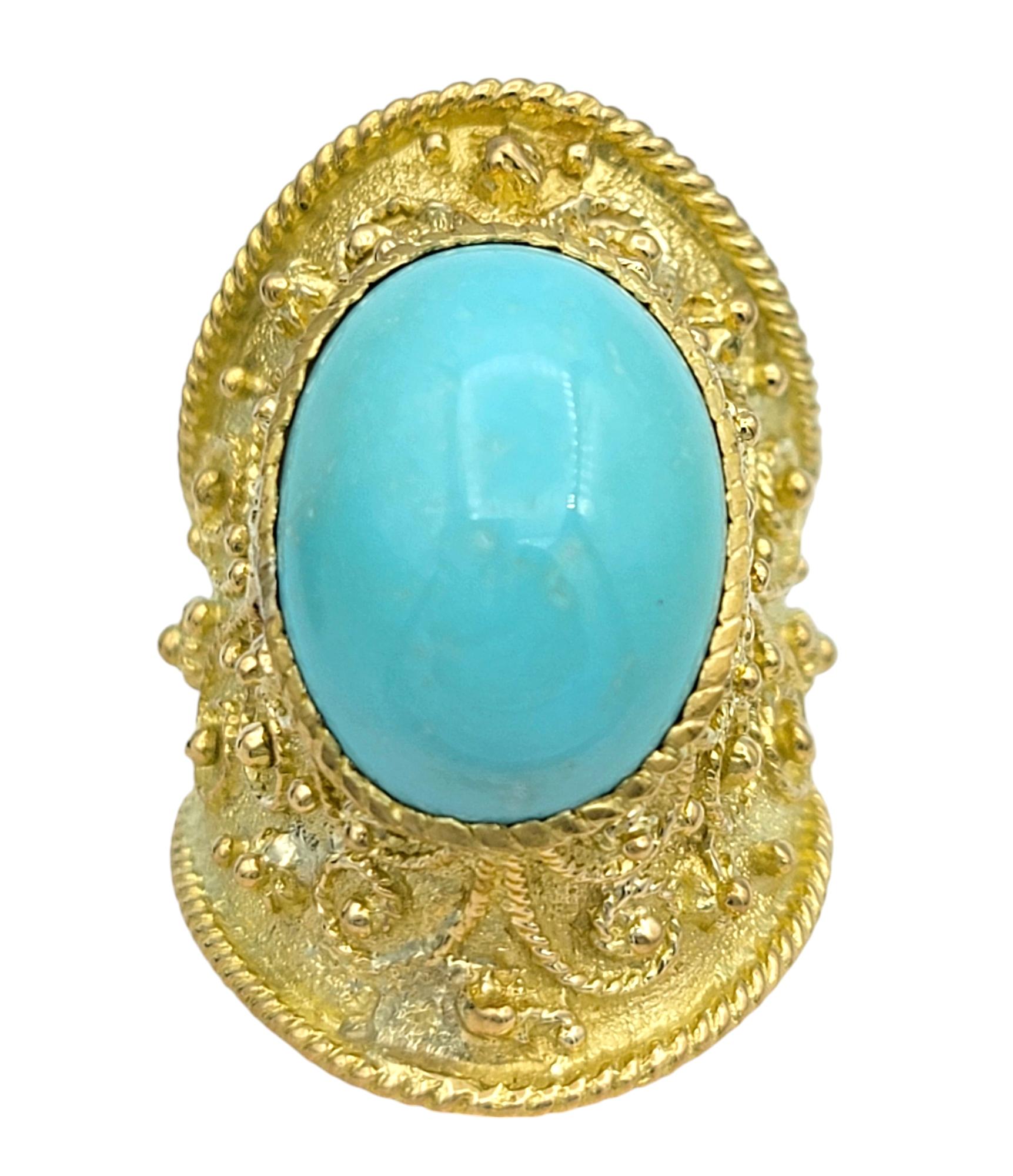 Taille de l'anneau : 7

Cette exquise bague de cocktail de style étrusque est un mélange captivant d'art ancien et de luxe moderne. Réalisée en or jaune 18 carats, cette bague est ornée d'une superbe turquoise ovale taillée en cabochon. La turquoise
