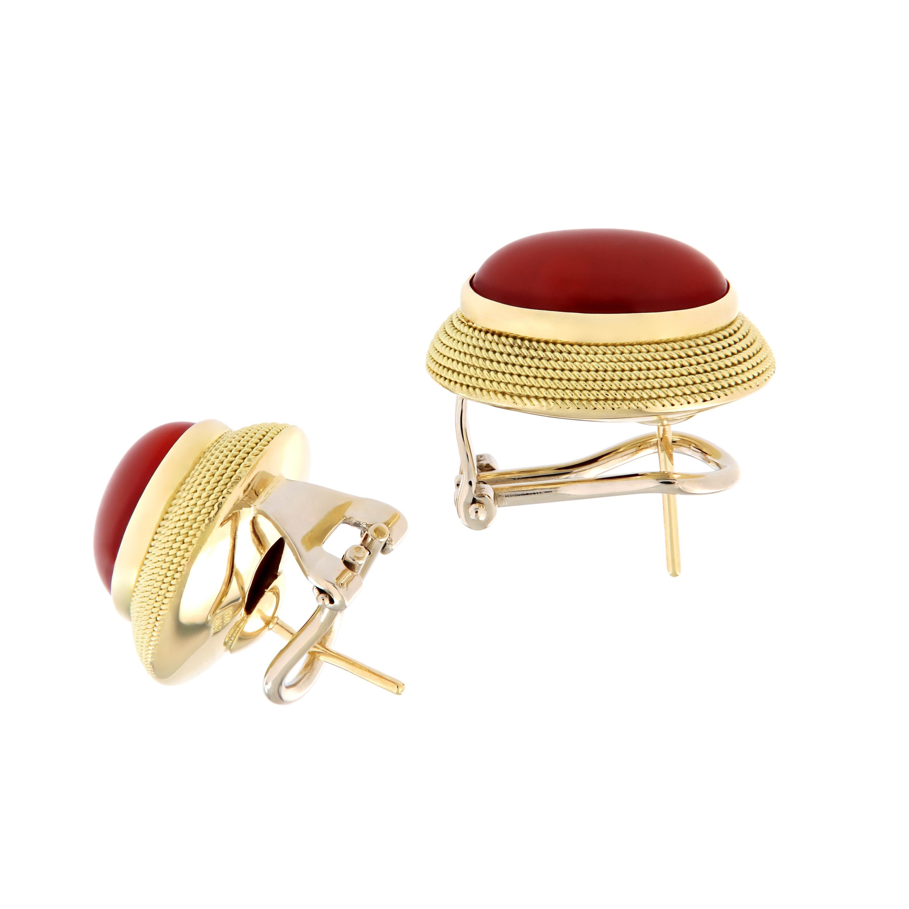 Oval cabochon red coral framed with a polished rope design are handcrafted in 18k yellow gold. The stud earrings have omega backs. Earrings measure 15mm x 19mm. Weigh 12 grams.

Coral measures 9mm x 13mm.