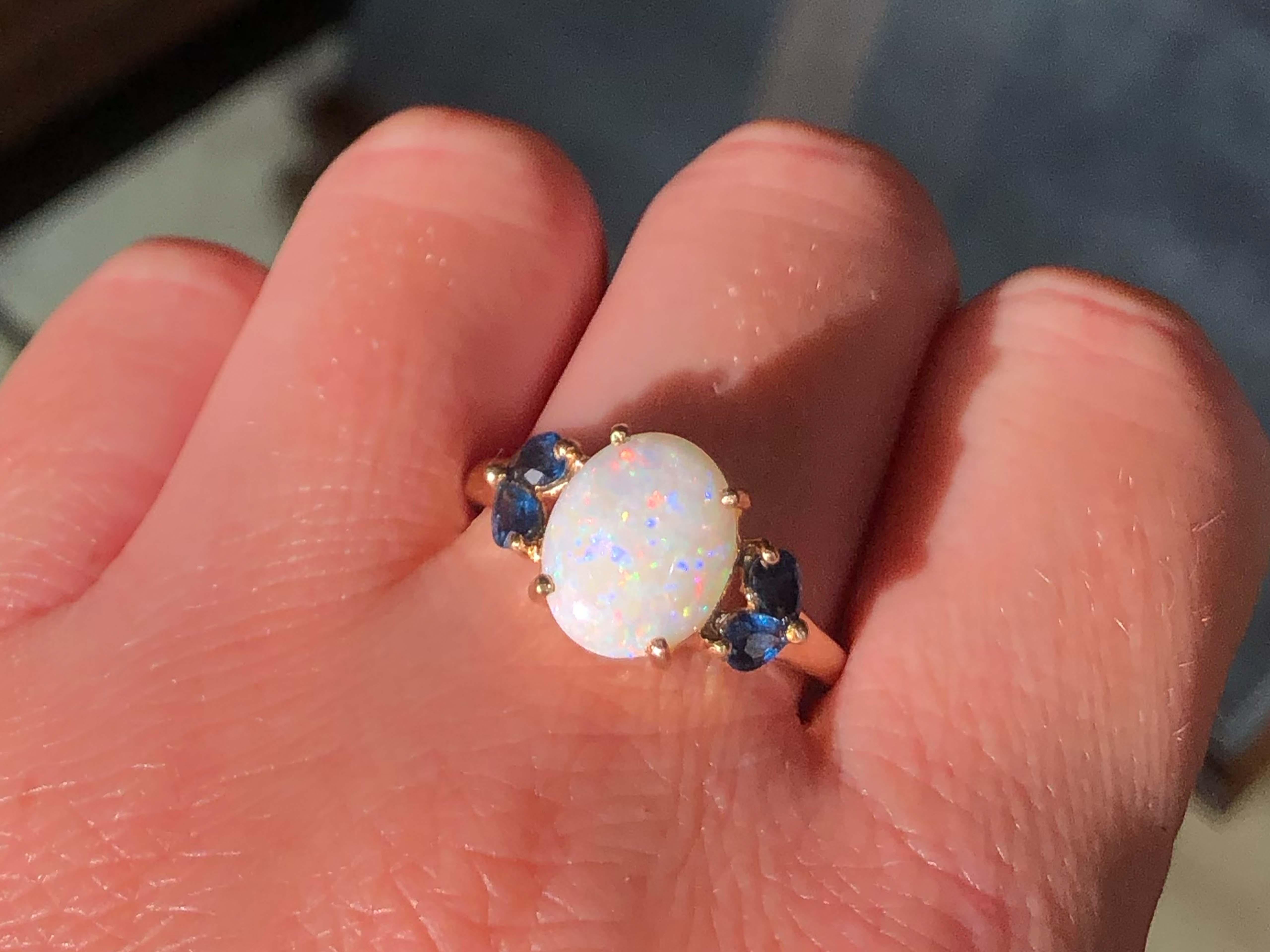 Item Specifications:

Metal: 14K Yellow Gold

Total Weight: 3.4 Grams

Ring Size: 11

Sapphire Count: 4 pear shaped sapphires

Opal Count: 1 oval cabochon opal

Opal Carat Weight: ~2.27 carats

Opal Measurements: 11.8 mm x 9.7 mm x 3.5