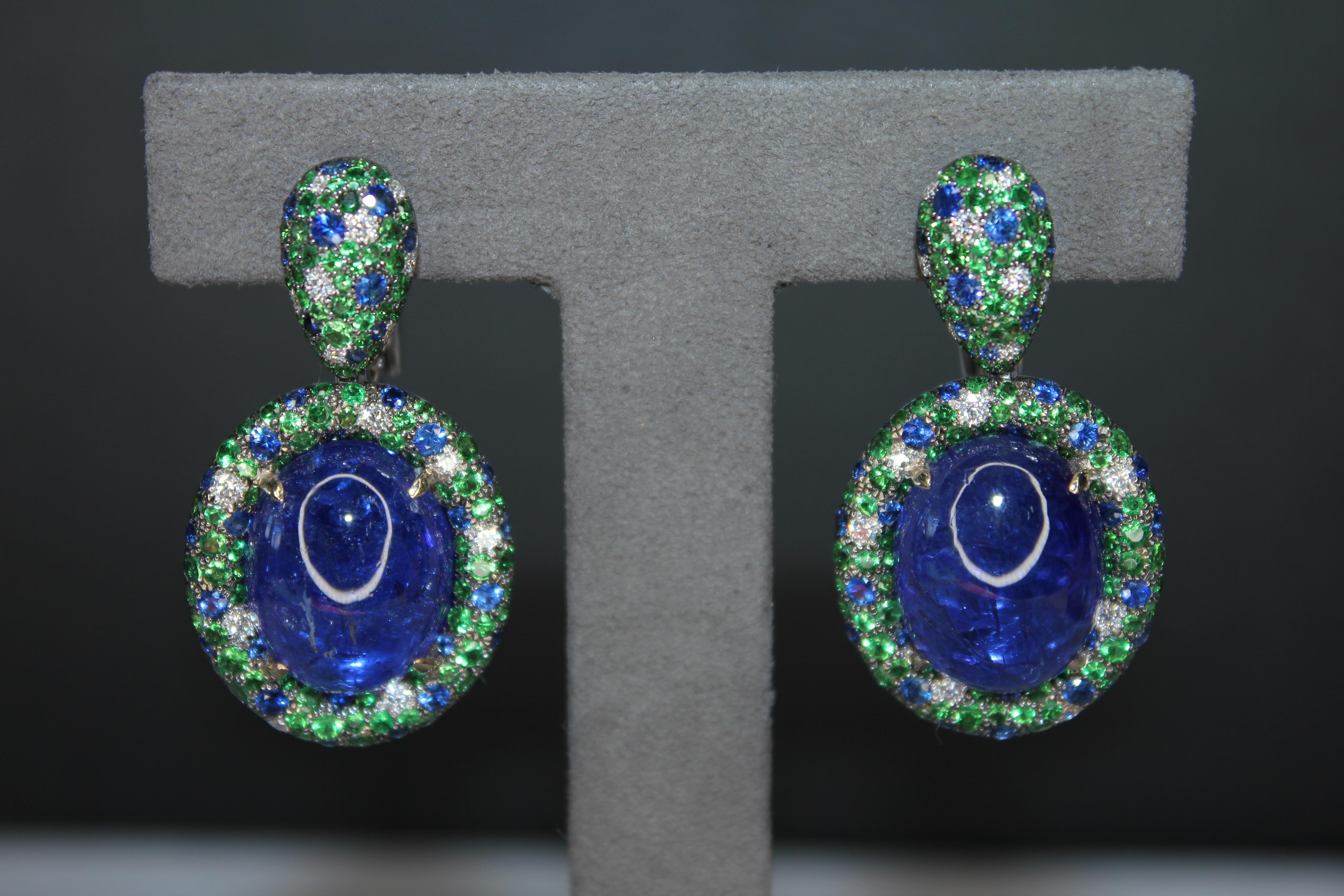 Orecchini ovali con cabochon di tanzanite, tsavorite, diamanti e pave in oro bianco 18 carati
Oro bianco 18 carati
Tanzaniti, Zaffiri blu, Tsavoriti e Diamanti autentici
30,00 carati di tanzaniti ovali a forma di cabochon
4.20 carati di Tsavorites