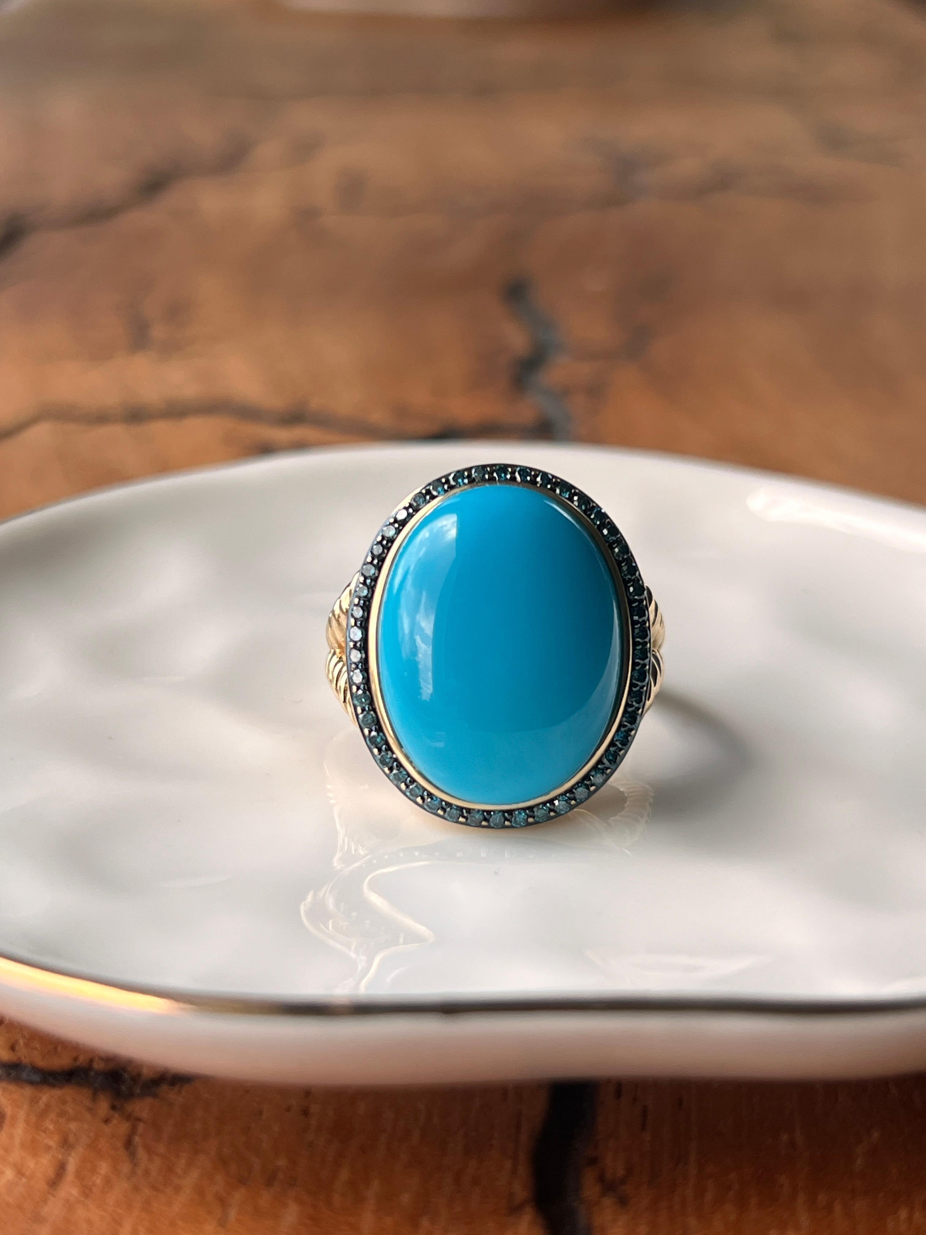A contemporary 14-karat yellow gold ring featuring a substantial 20 x 15mm oval turquoise cabochon in classic sky-blue. The turquoise is surrounded by forty-six round brilliant blue diamonds totaling approximately 0.37 carats with SI2 clarity,