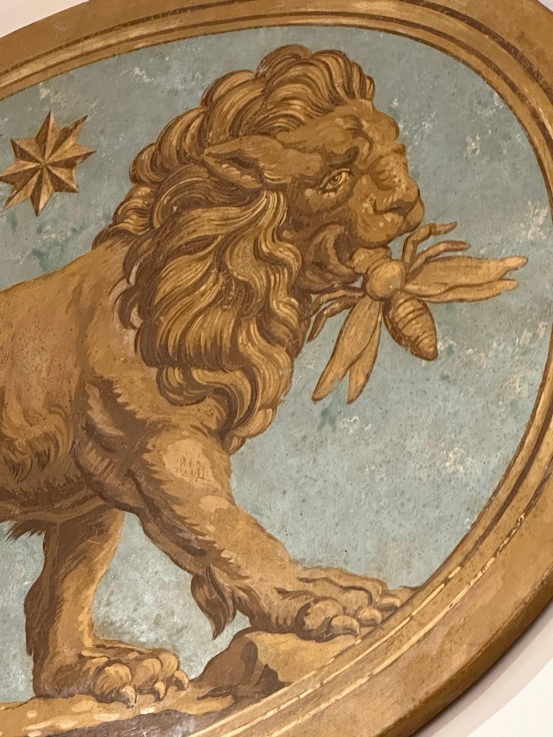 Une magnifique toile ovale peinte à la main représentant un lion avec une abeille en guise de porte.  