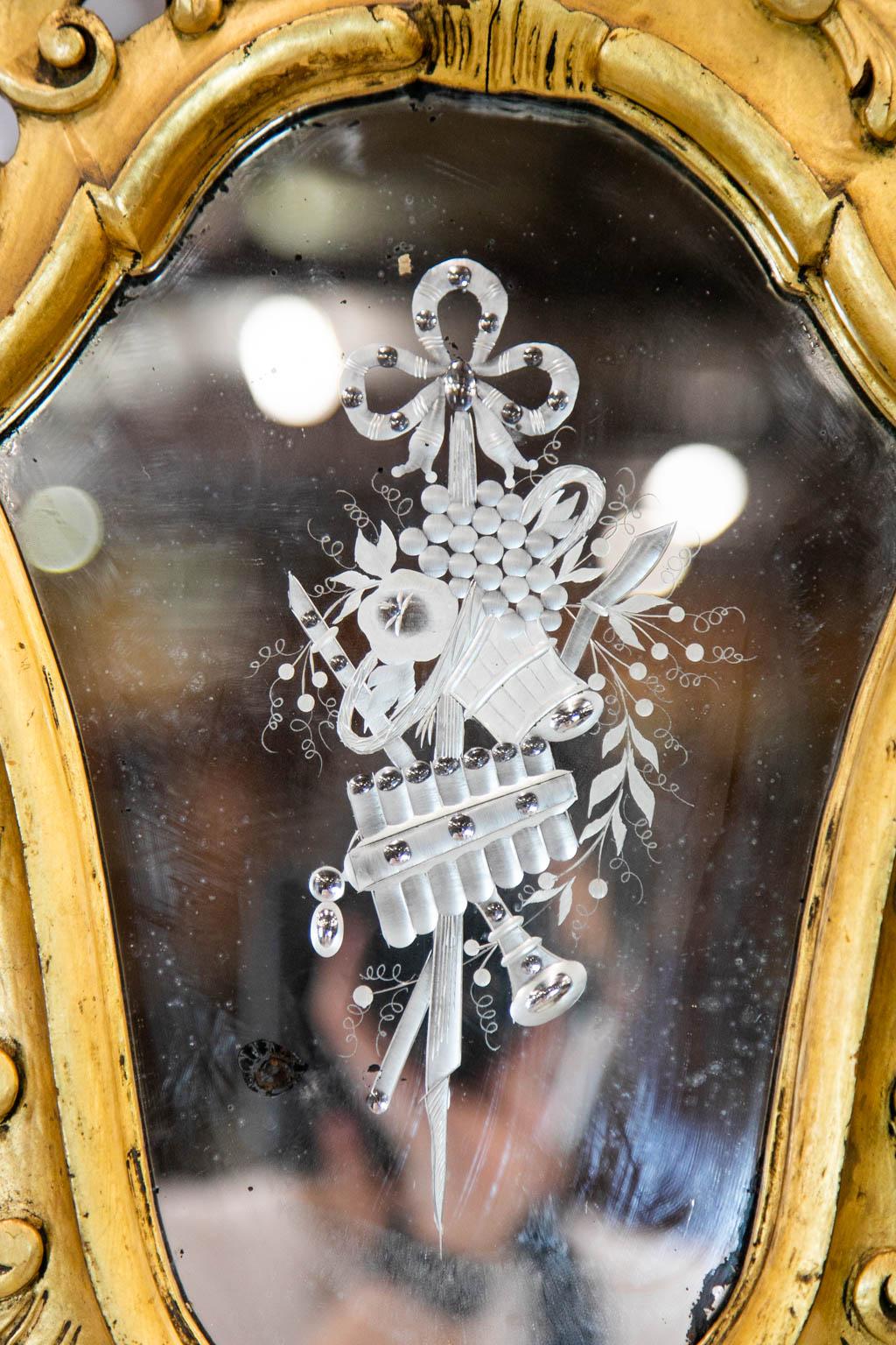 Dieser französische Spiegel hat einen Rahmen aus vergoldetem Gesso. Es gibt einen dreifachen Kerzenständer, der von einem geschnitzten Amor getragen wird, der an den Zehen beschädigt ist. Dies könnte auf Wunsch wiederhergestellt werden.