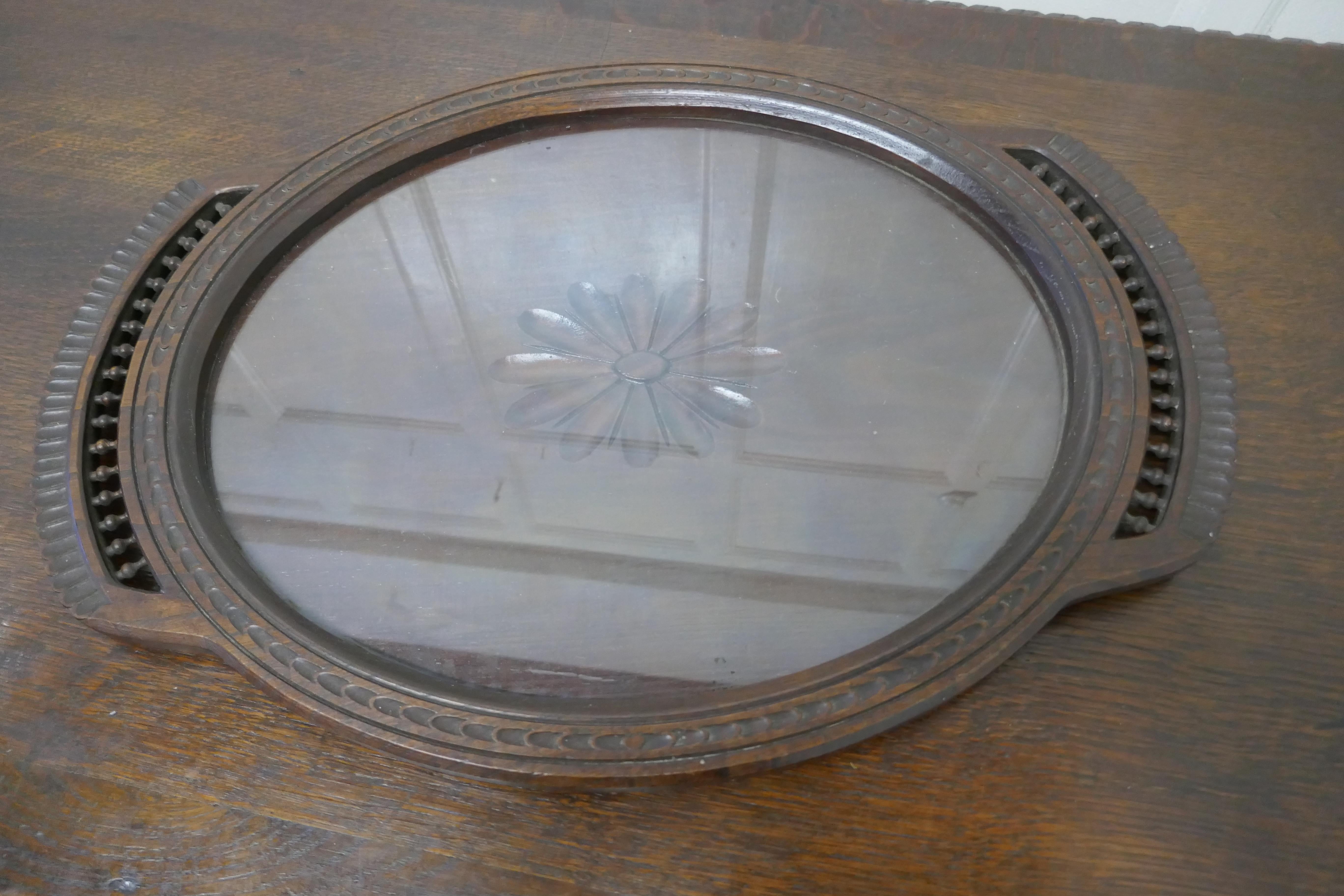 Oval Carved Oak Breton Country Tray 

A good honest piece, the tray is made in oak, it has a raised gallery and handles which are carved in the Breton style and in the centre under glass a Sun Flower
A great piece in good condition 
The tray is