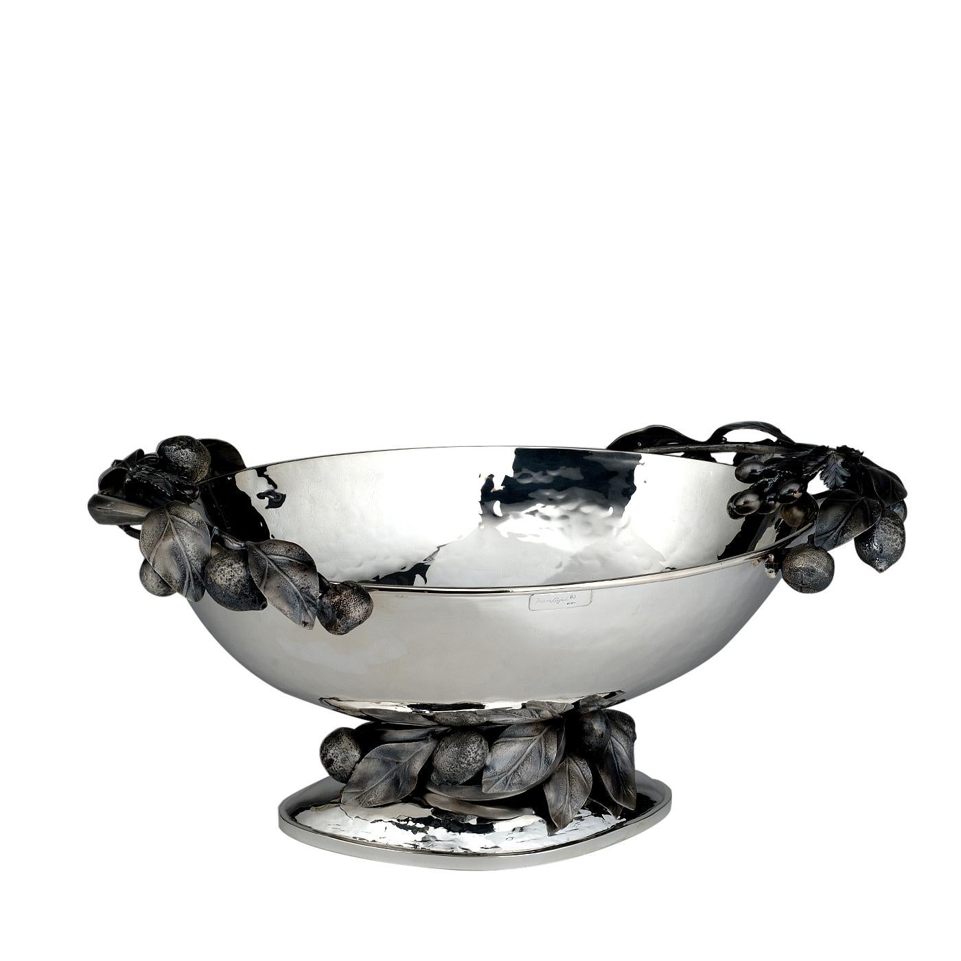 Elegant and sophisticated, this centerpiece will enrich a classic dining room or living room, with its exquisite craftsmanship and the vivid details of its decorations. The generous, oval bowl rests on a small plinth base and both the areas of the