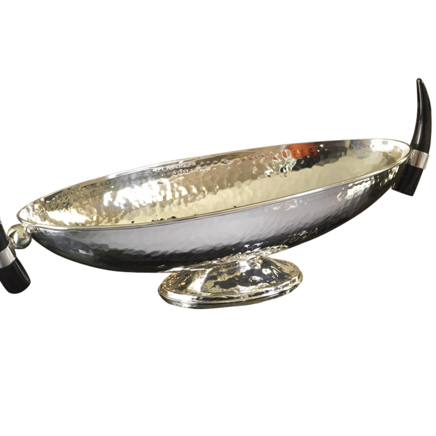 Un classique intemporel qui fera une présentation glamour sur une table à manger ou une console, cette pièce centrale ovale de la collection Horn est fabriquée à la main en laiton argenté par des maîtres orfèvres. Le piédestal ovale met en valeur la