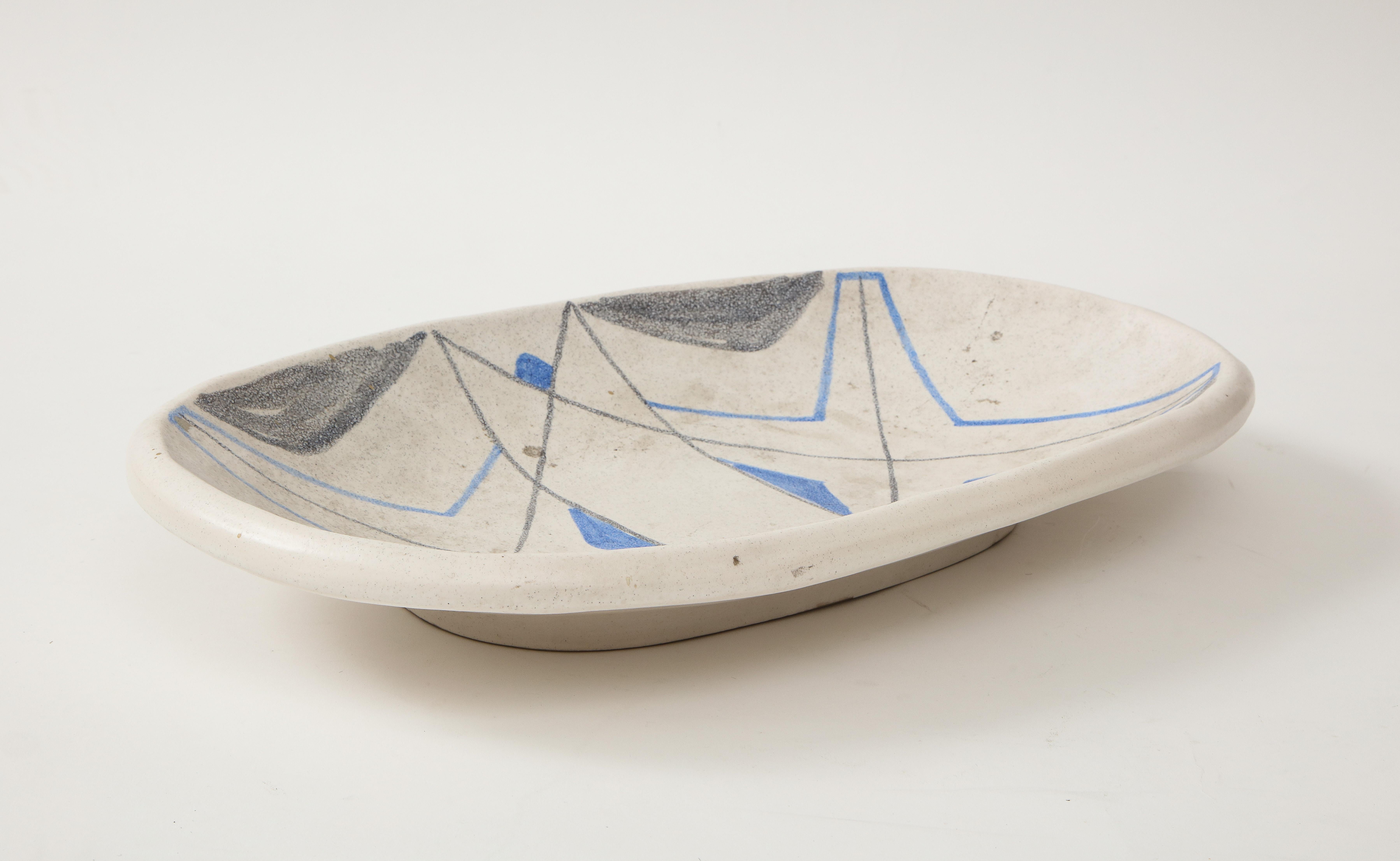 Stunning oval ceramic tray, Vallauris, France, circa 1950. 

This object's exquisite three-tone composition consists of a stunning blue and black geometric design cast against a soft grey base. This ceramic has the unique distinction of hailing
