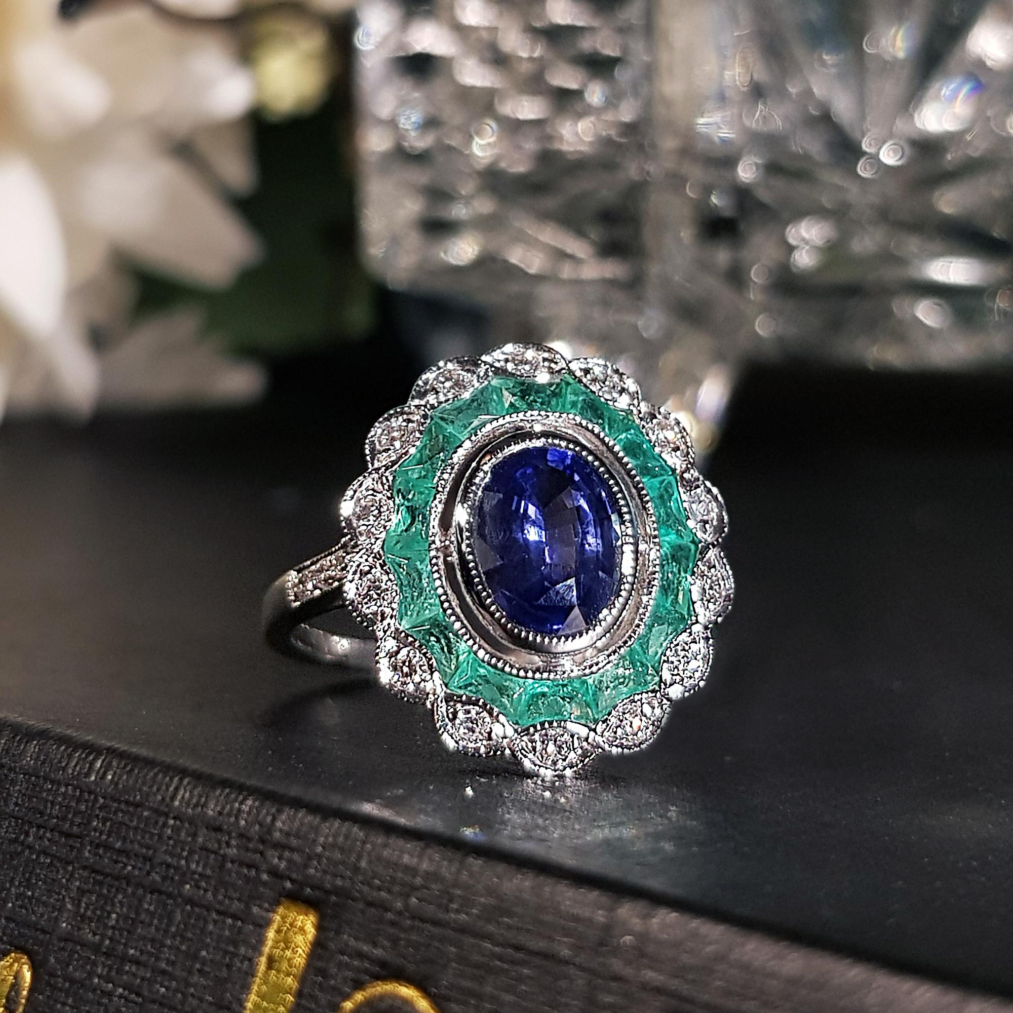 Centering an oval cut Ceylon Sapphire, accented by French cut Emeralds, enhanced by round cut diamonds. This Art Deco inspired ring is a perfect piece for an engagement ring, or to commemorate an anniversary.

Ring Information
Style: Art-deco
Metal: