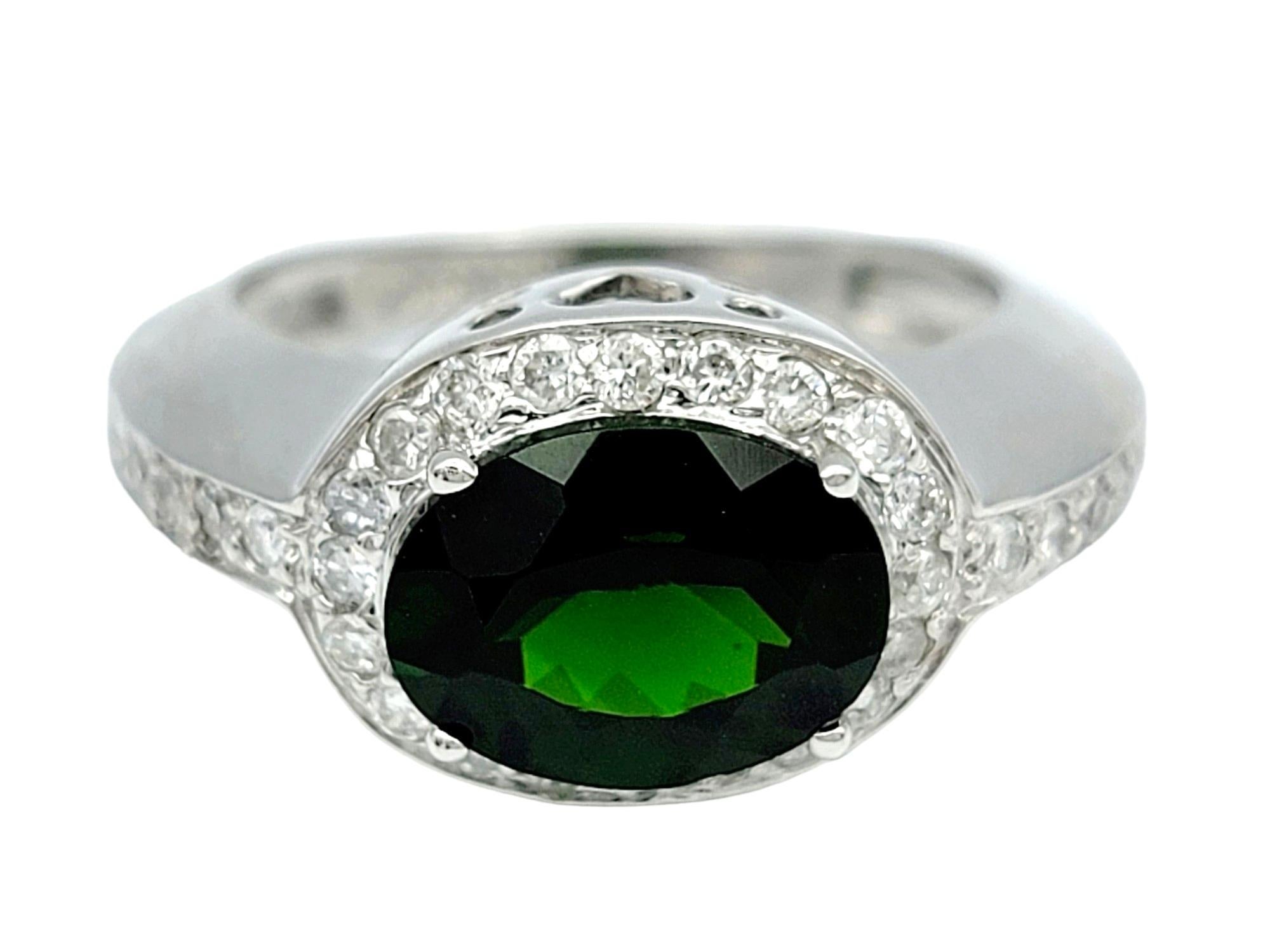 Ring Size: 5.25

Exuding a captivating allure, this ring features a mesmerizing oval chrome diopside embraced by a radiant halo of diamonds, all elegantly horizontally set in lustrous 14 karat white gold. The deep, lush green hue of the chrome