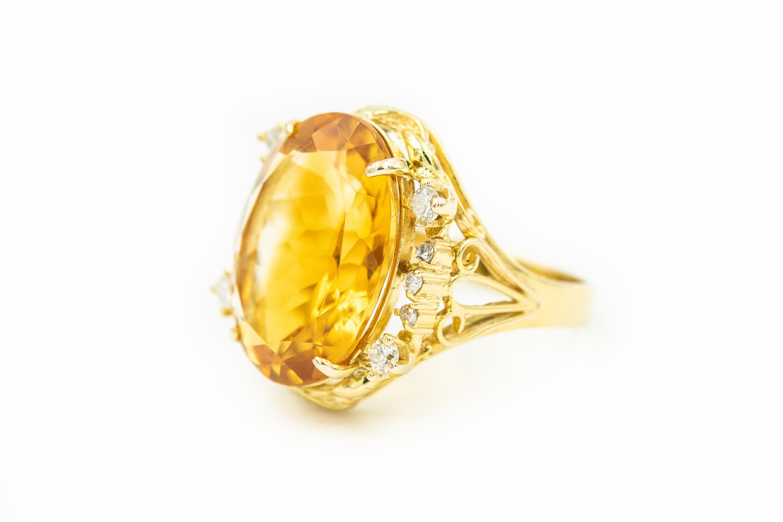 Gorgeous yellow orange color oval faceted citrine accented with 4 prong set approximate size .08 carat diamonds and six 3 prong set approximate .02 carats diamonds. Approximate total weight in diamonds is .44 carats. The sides have open scroll