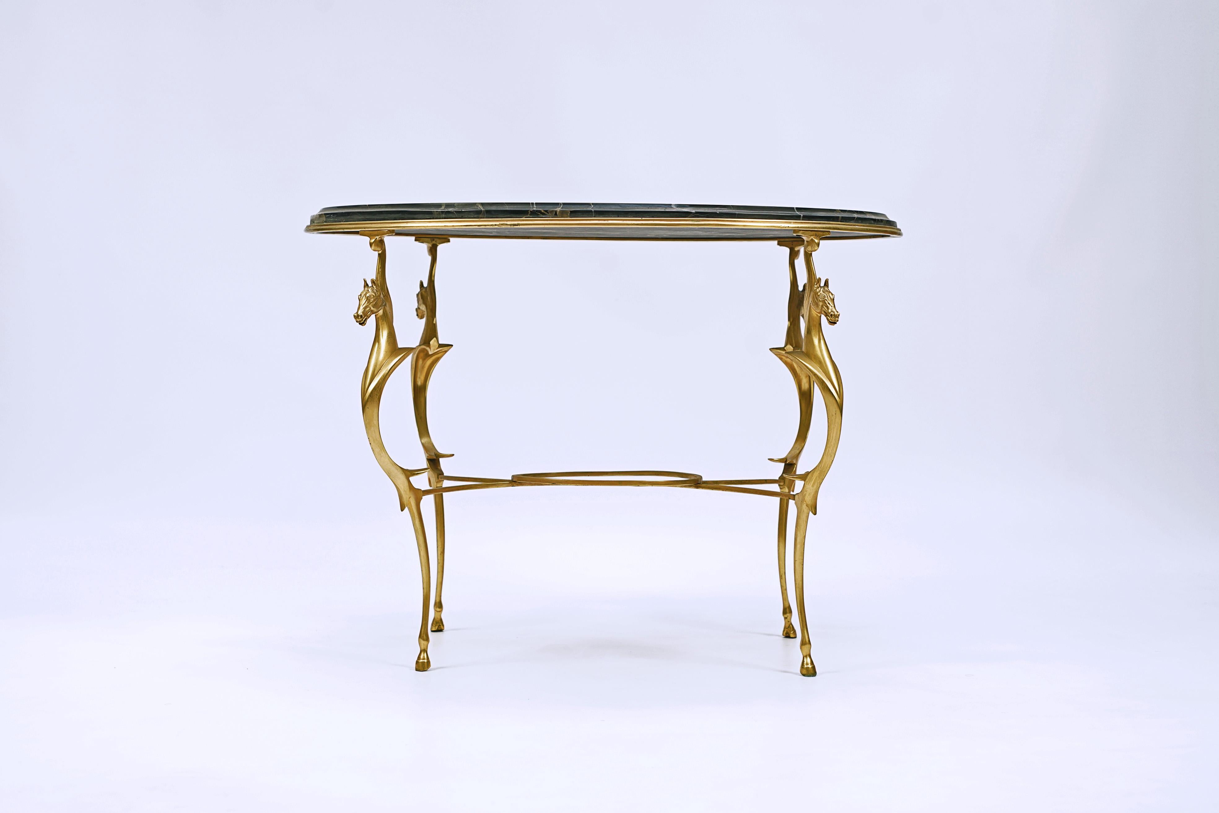 Table basse ovale conçue par Andre Arbus (1903-1969). Bronze doré et plateau en marbre portoro.

France, CIRCA 1940. 
