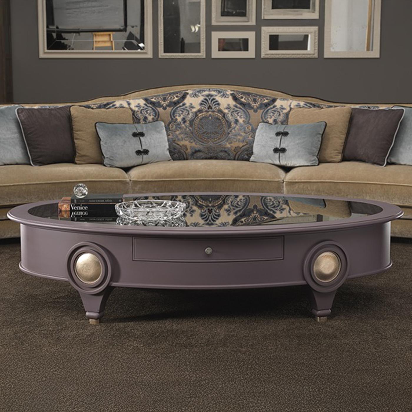 Cette table basse ovale est fabriquée en bois laqué et comporte deux tiroirs pratiques et un élégant plateau en bois avec un miroir fumé. Le processus de finition comprend de nombreuses étapes manuelles méticuleuses utilisant des produits à base