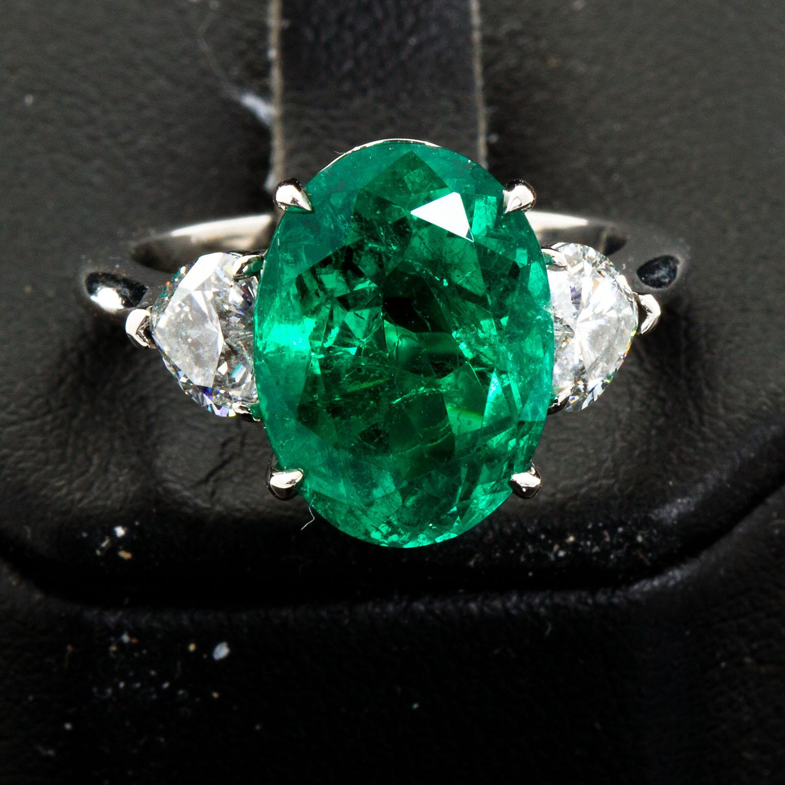 oval diamond with emerald side stones