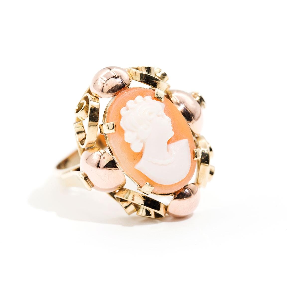 Lovingly crafted in 14 carat yellow and rose gold is this charming vintage Conch Shell Cameo vintage ring. Romance was in mind when this ring was created.  The cameo is breathtakingly graceful sitting in the scrolled setting forged in both yellow