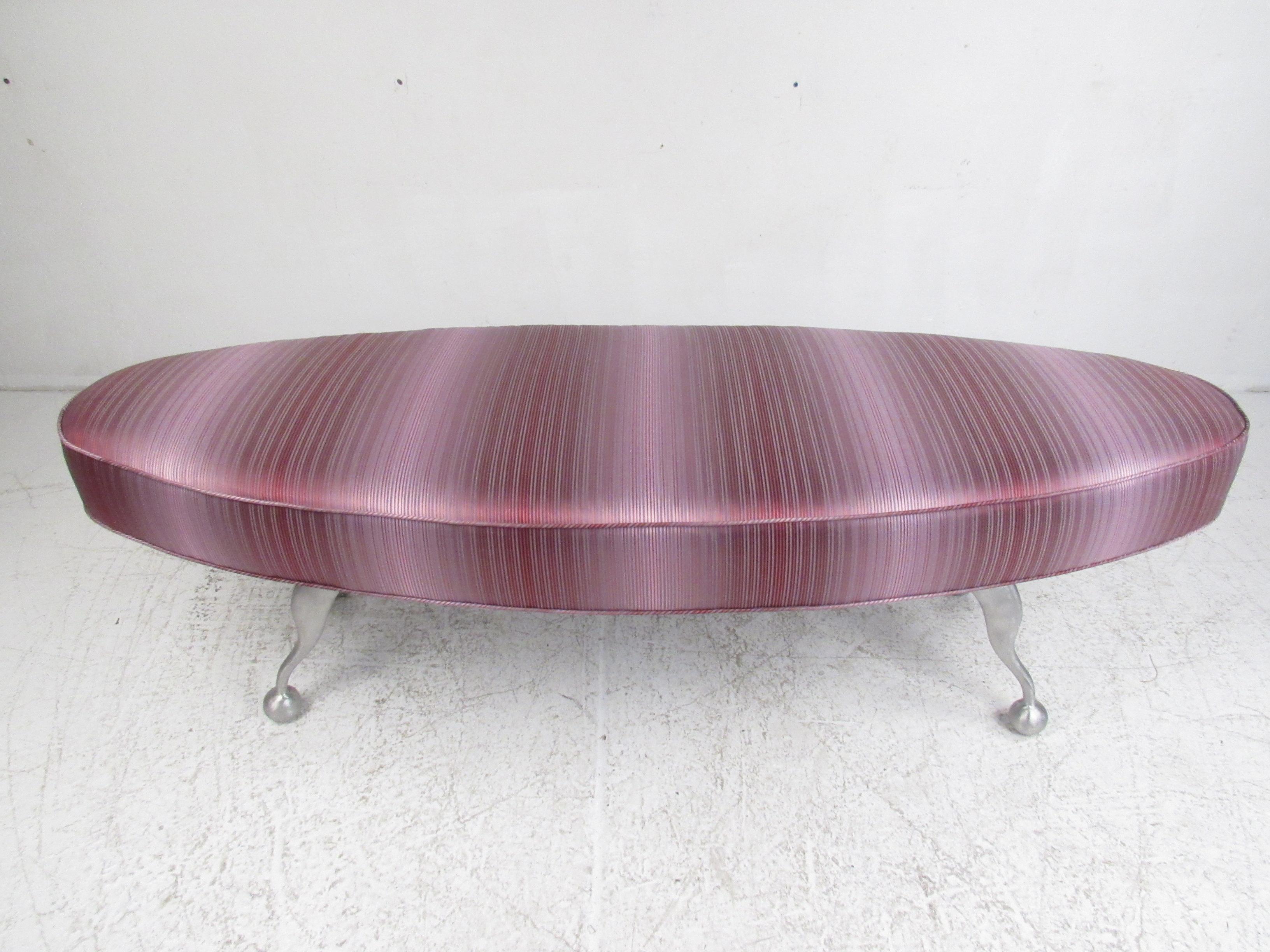 This stylish contemporary modern bench or foot stool features an elaborate striped upholstery and unusual sculpted metal legs. An overstuffed oval seat and wavy drumstick shaped legs make this beautiful bench stand out from the rest. This versatile
