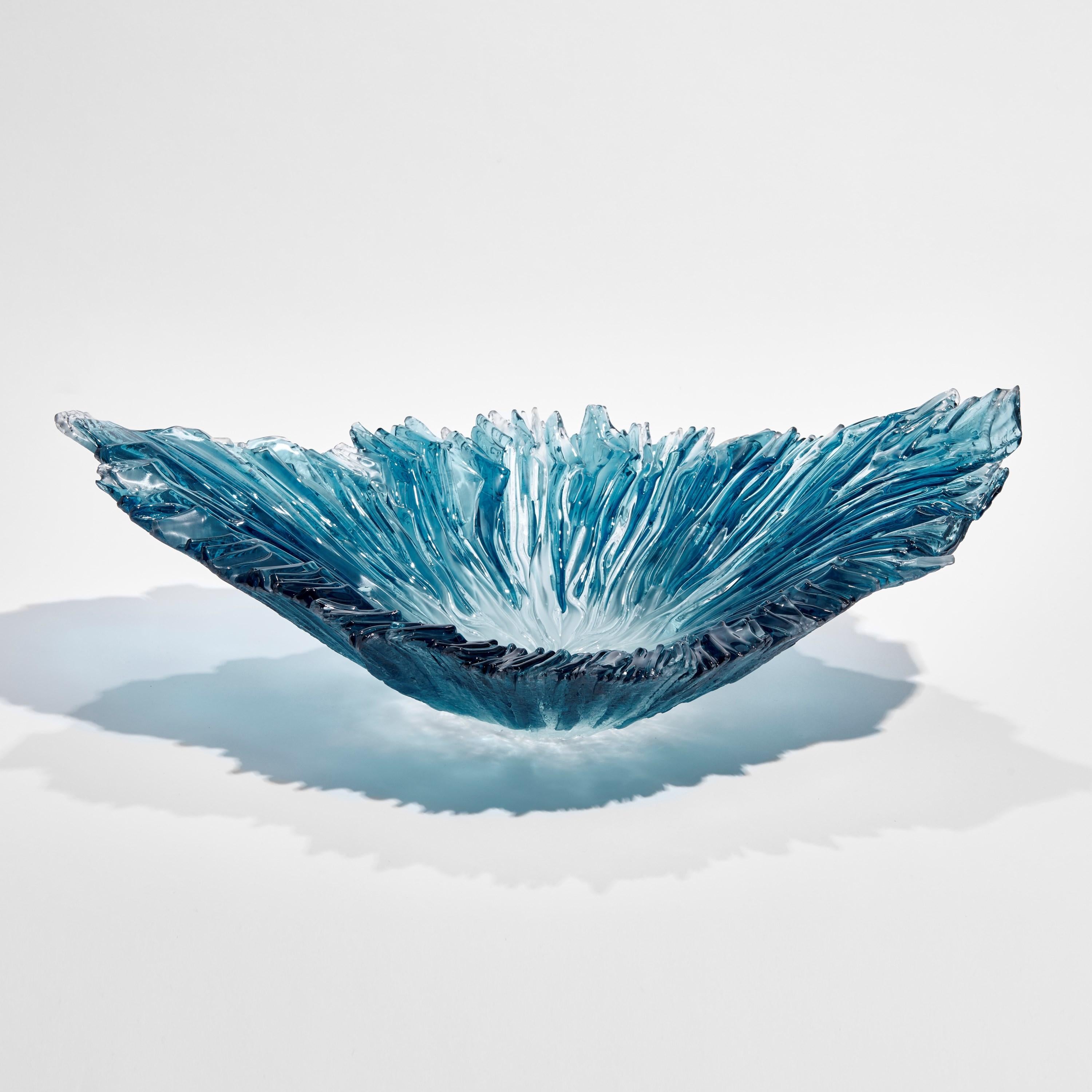 'Oval Coral Bowl in Aqua' is a unique artwork created by the British artist, Wayne Charmer. 

For Wayne Charmer, the fascination of glass is to exploit its translucent and reflective qualities. Inspired by nature, his signature techniques for his