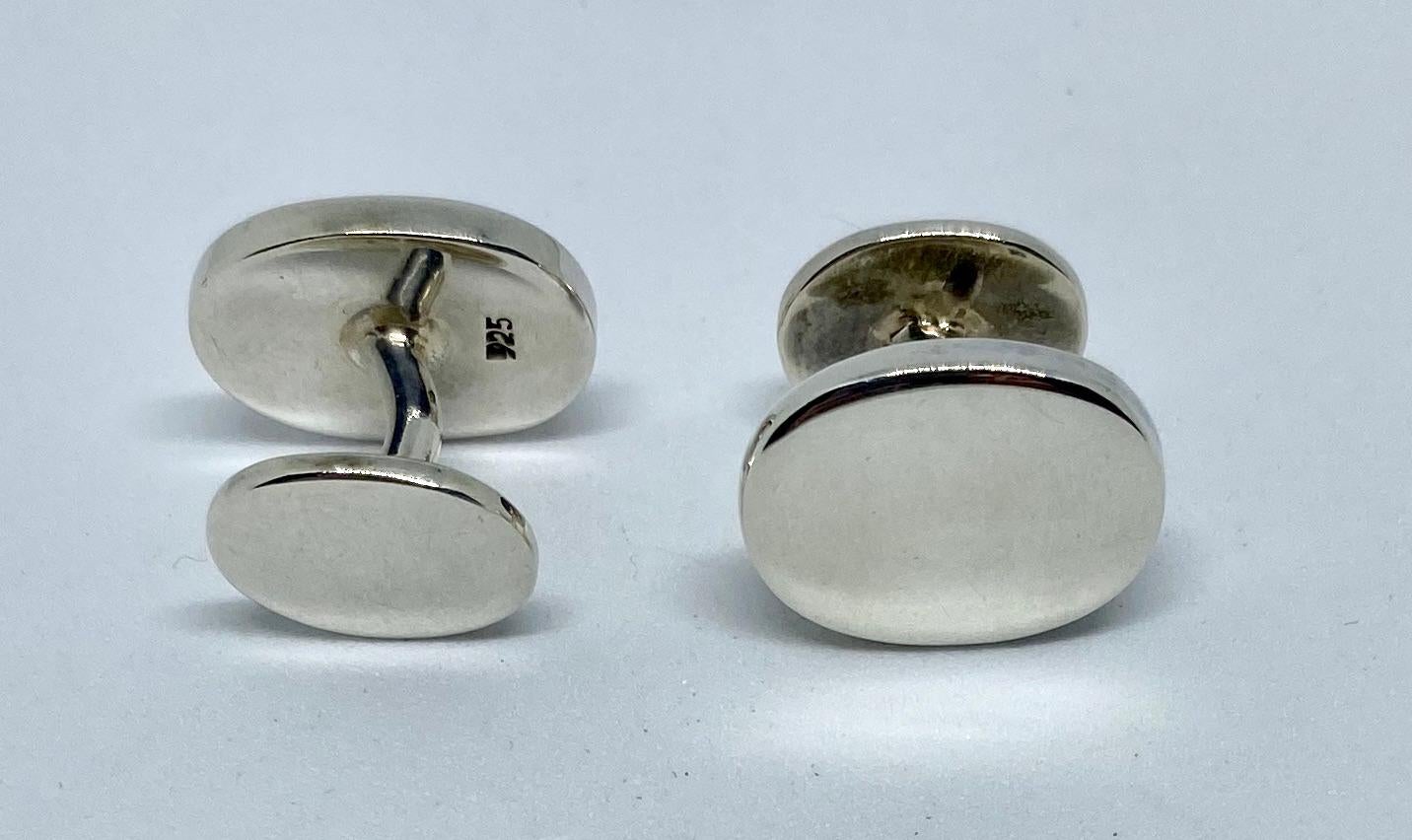These heavy, classic oval cufflinks are very well made and slip easily into the buttonholes of a shirt cuff. 

The fronts measure 17 by 13mm, while the backs measure 13 by 10mm. They are connected by a solid silver bar. Together, the cufflinks weigh