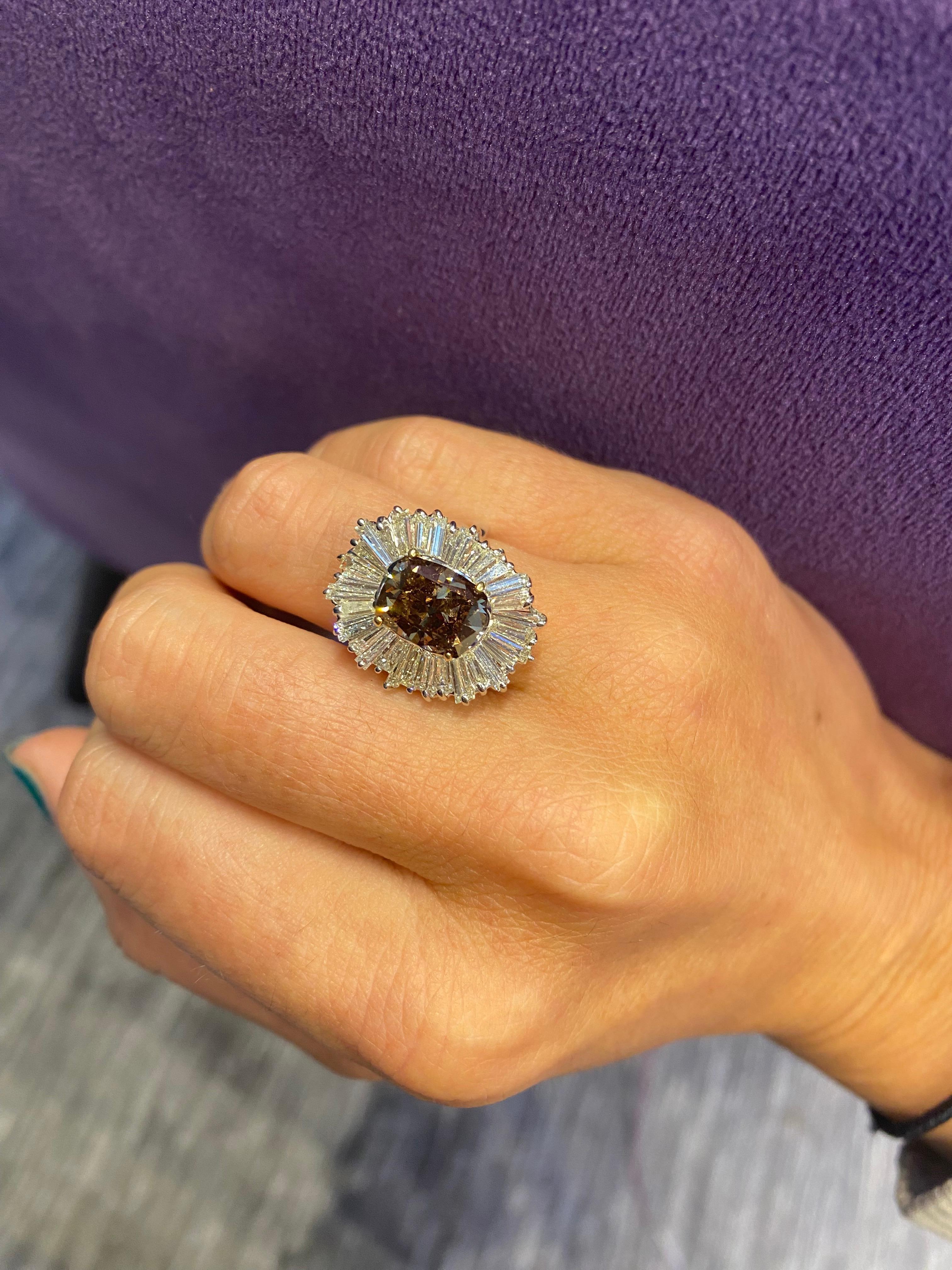Oval Cushion Cut Brown Diamond Ballerina Ring

A white gold ring set with a center oval cushion cut light brown diamond, weighing approximately 3.37 carats, framed by 32 baguette cut diamonds weighing approximately 2.66 carats

Ring Size: 5.75
14