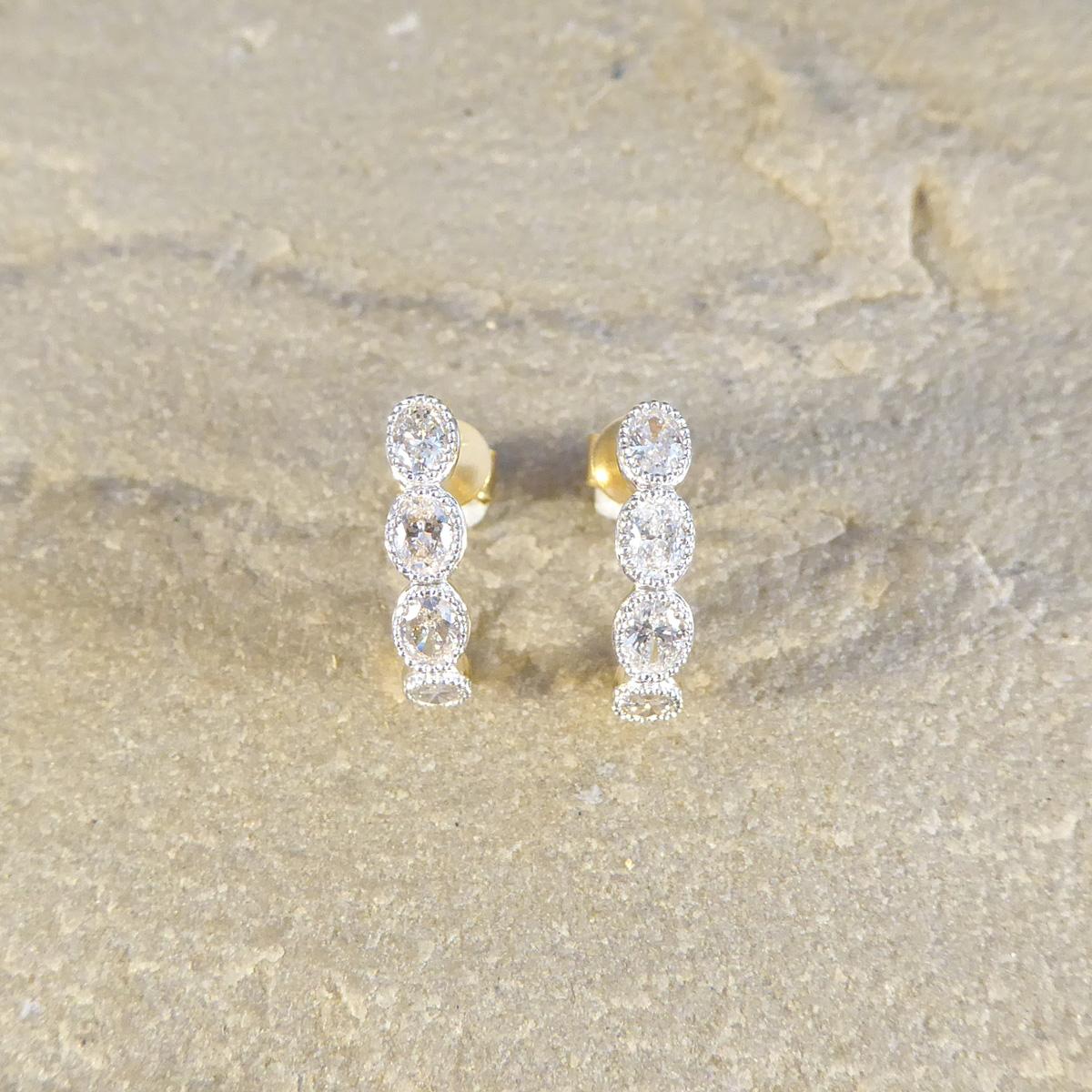 The most beautiful huggie hoop earrings set with Diamonds that sparkle throughout. Each half hoop are set with four Oval Cut Diamonds of equal colour and clarity in a rub over millegrain detailed setting in 18ct White Gold to compliment the stones,