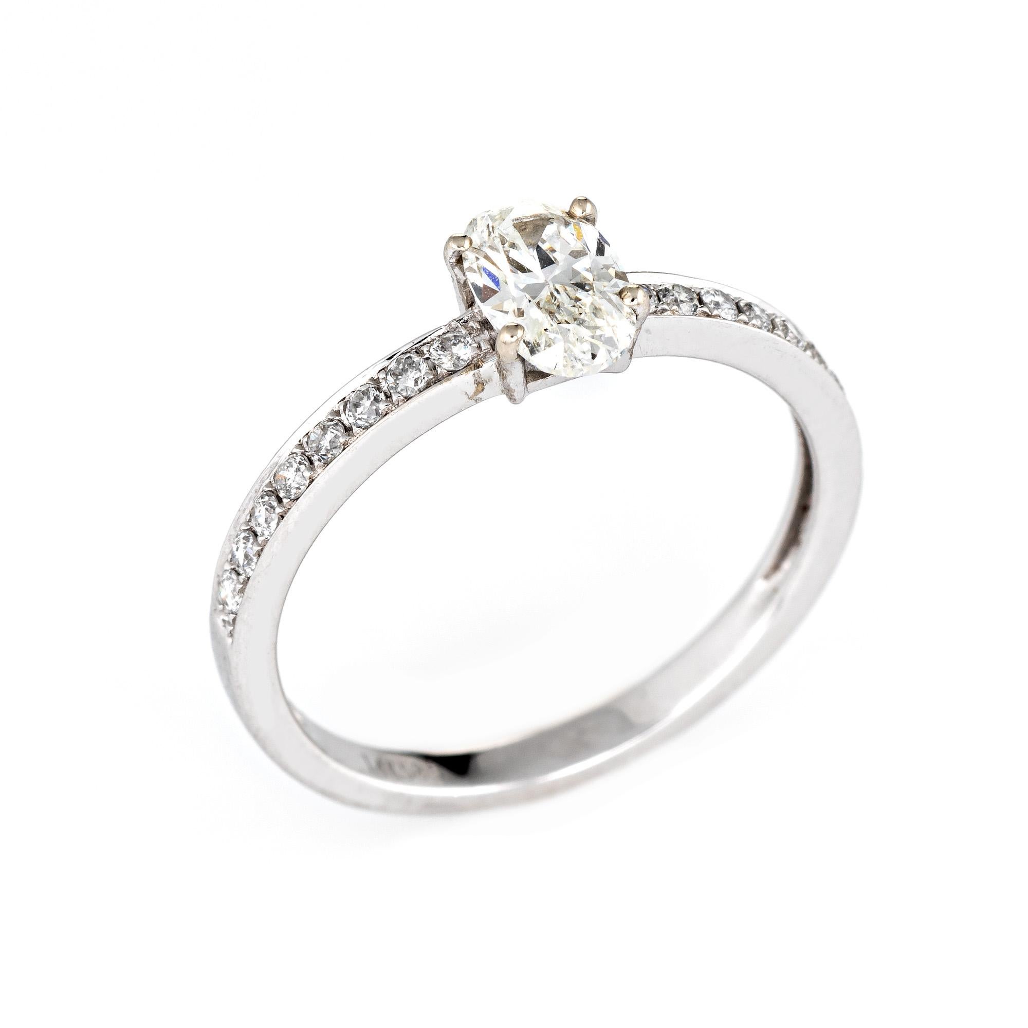 Stylish diamond engagement ring crafted in 14 karat white gold. 

Centrally mounted oval cut diamond is estimated at 0.86 carats, accented with 16 estimated 0.01 carat diamonds. The total diamond weight is estimated at 1.02 carats (estimated at I-J