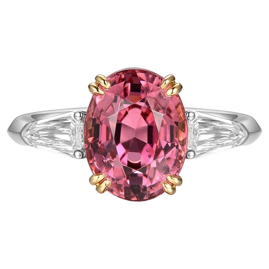 Introducing our breathtaking Oval Cut 3.93 Carat Pink Tourmaline Diamond Three-Stone Ring in 18 Karat Gold. This exquisite piece of jewelry combines the vibrant allure of pink tourmaline with the timeless elegance of diamonds. The center stage is