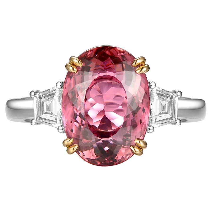 This ring features a oval cut 4.29 carat pink tourmaline, assented with 2 fancy cut diamonds on the shoulder. Each diamond weight 0.22 carat. The two diamonds are E color and VS clarity. A modern yet classic design. Tourmaline is set in 18 karat