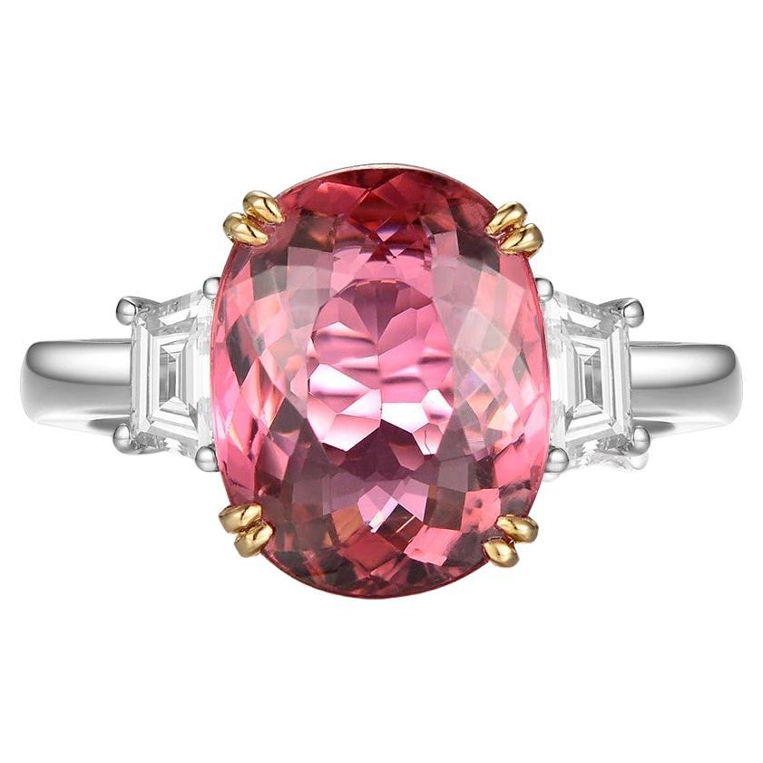 This ring features a oval cut 4.29 carat pink tourmaline, assented with 2 fancy cut diamonds on the shoulder. Each diamond weight 0.185 carat. The two diamonds are E color and VS clarity. A modern yet classic design. Tourmaline is set in 18 karat