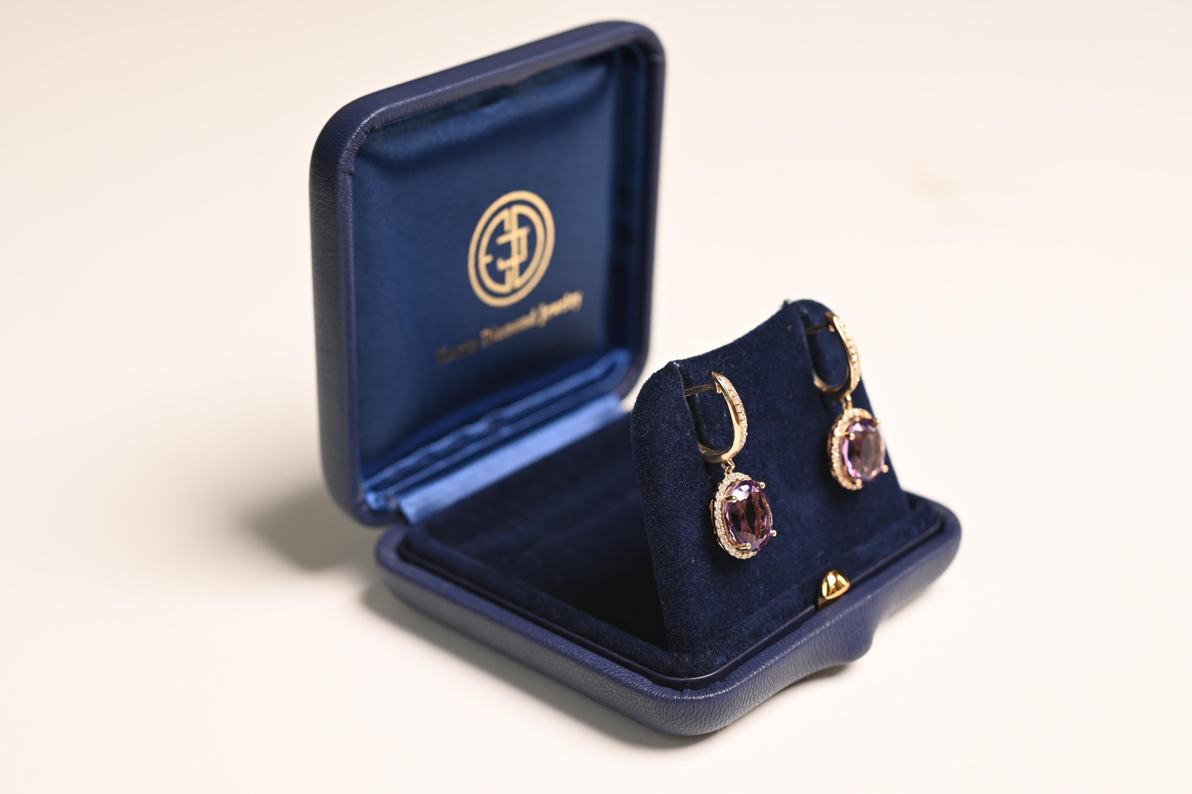 Ces boucles d'oreilles pendantes en pierres précieuses sont un exemple étonnant de savoir-faire artisanal, avec deux améthystes taillées en ovale et magnifiquement serties sur des griffes. Les améthystes, d'un violet riche et profond, sont entourées
