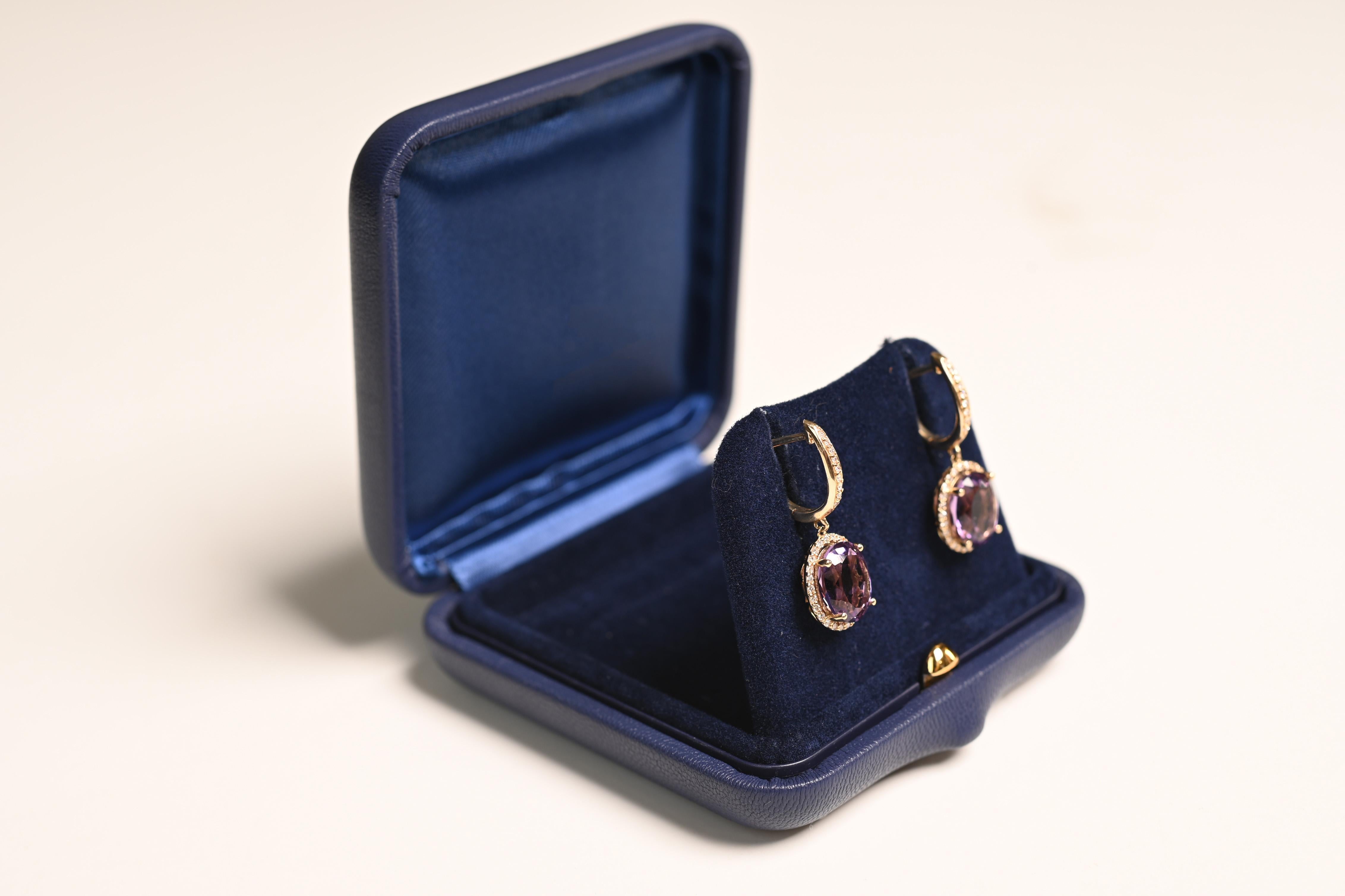 Ces boucles d'oreilles pendantes en pierres précieuses sont un exemple étonnant de savoir-faire artisanal, avec deux améthystes taillées en ovale et magnifiquement serties sur des griffes. Les améthystes, d'un violet riche et profond, sont entourées