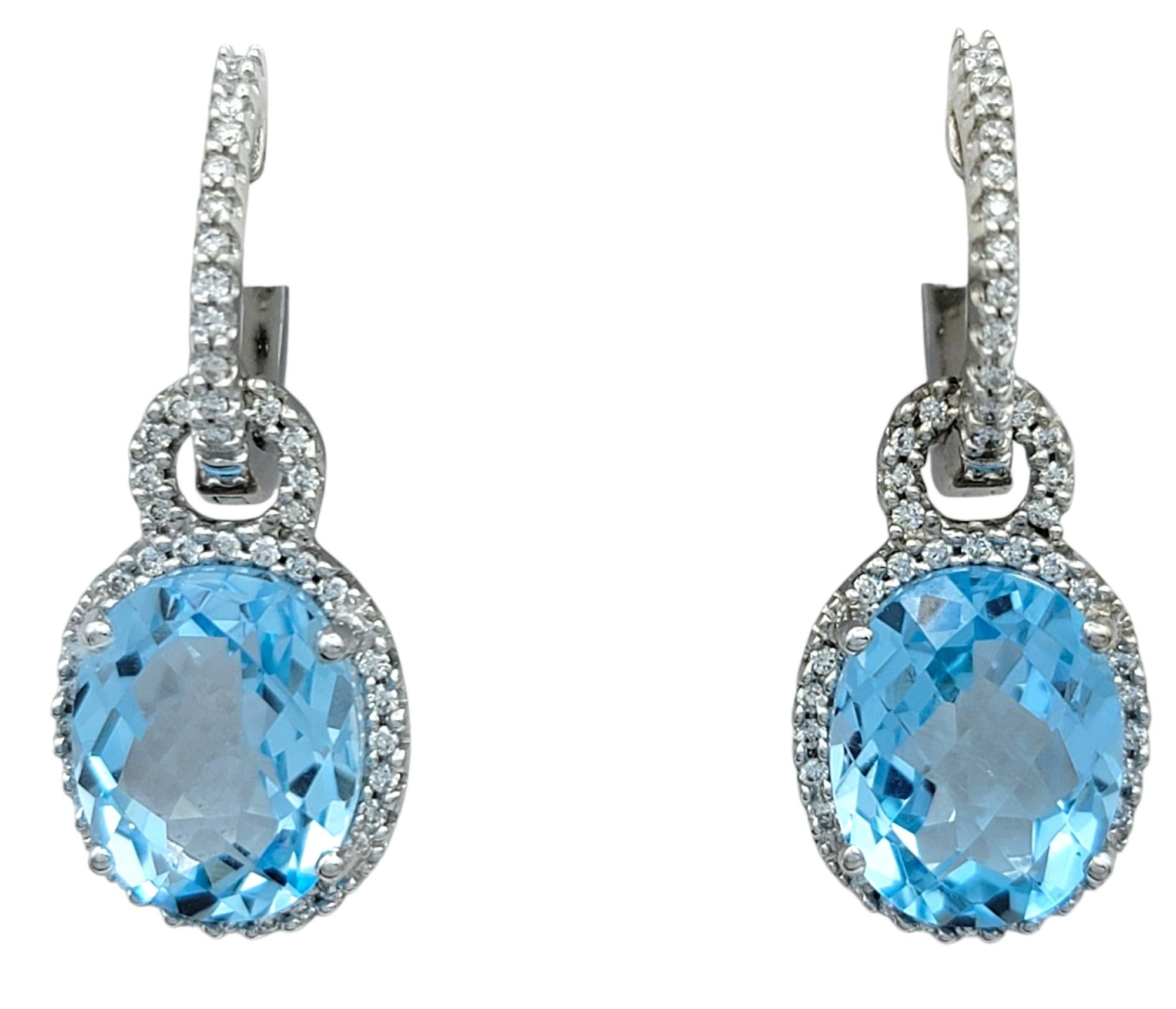 These gorgeous earrings feature vivid oval-cut aquamarines that radiate a light blue hue, suspended delicately below diamond-accented hoops. The aquamarines are set to capture light from every angle, showcasing their clarity and serene tone.

Above