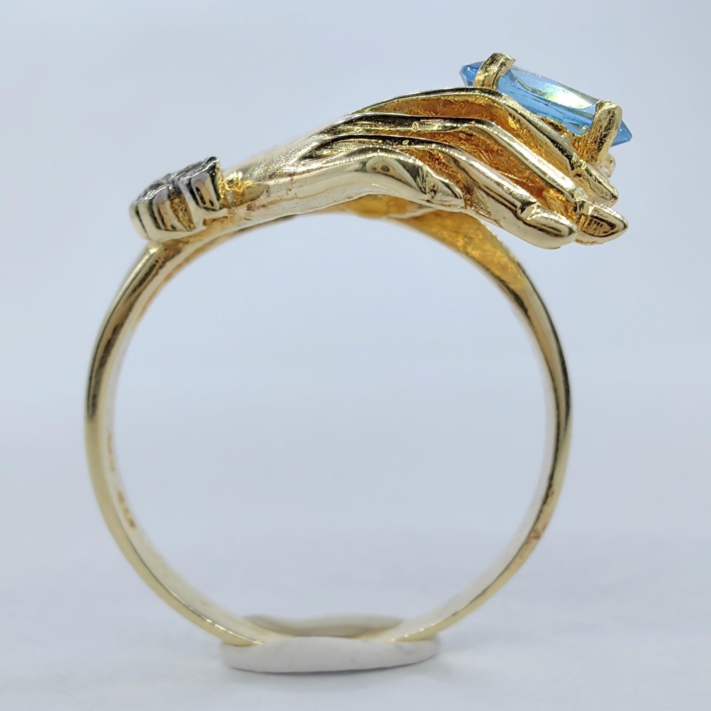 Oval Cut Oval-cut Blue Topaz in a Hand Diamond Ring in 14K Yellow Gold For Sale