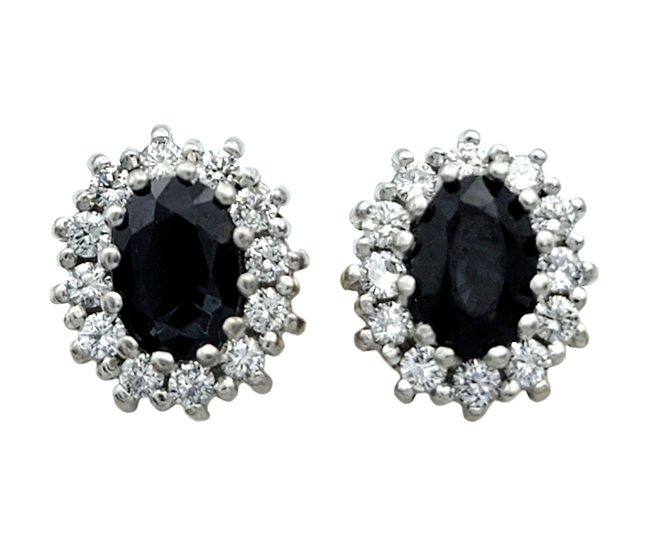 Diese atemberaubenden Ohrringe haben tiefschwarze Mittelsteine, die einen starken Kontrast zu ihren hellen, funkelnden Umgebungen bilden. Die ovale Form der Saphire verleiht jedem Ohrring eine glatte, elegante Silhouette. Die Zentren werden von