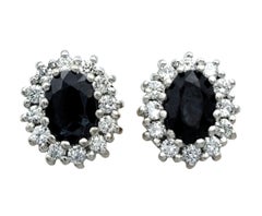 Oval Cut Black Sapphire and Diamond Halo Stud Earrings in Two Tone 18 Karat Gold