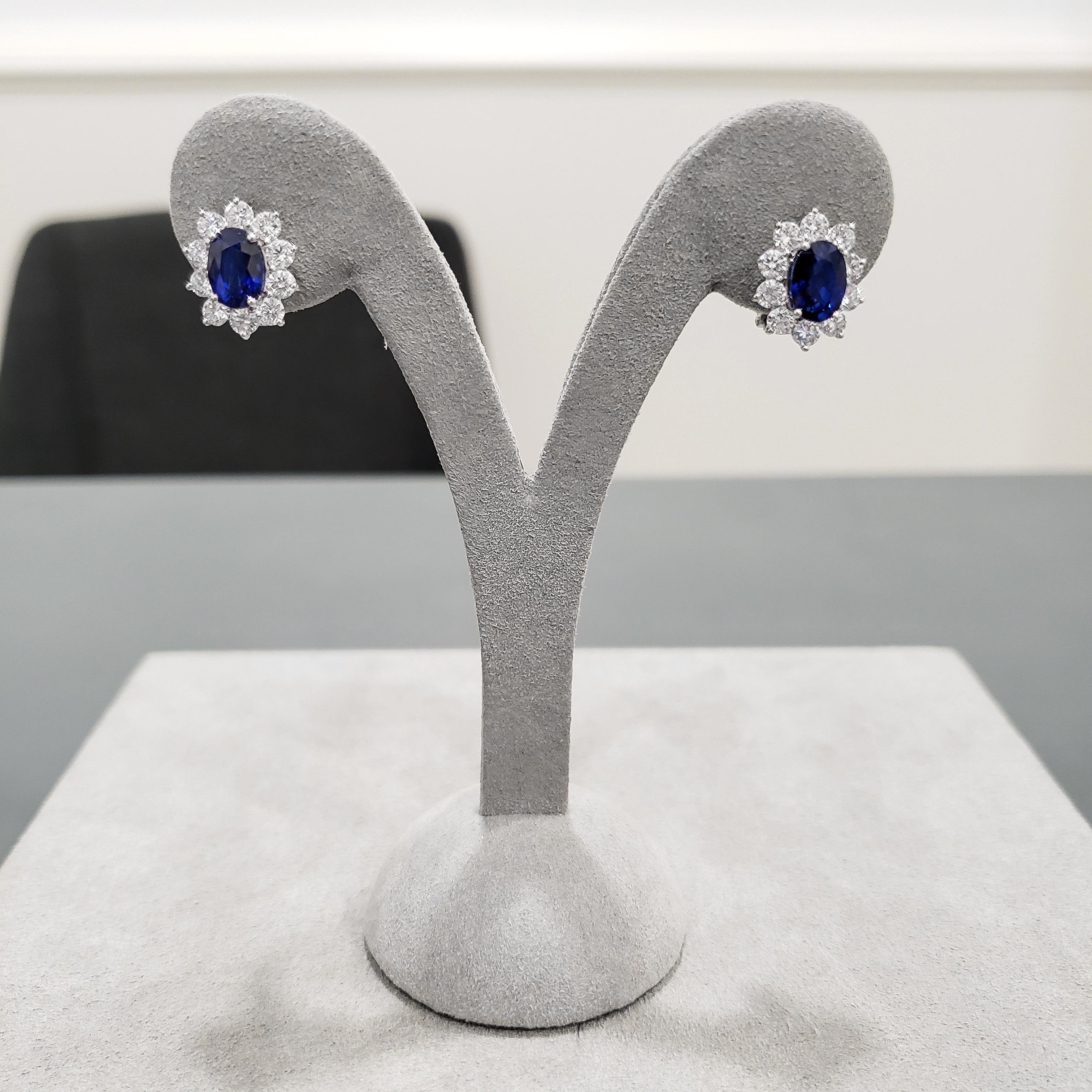 These classic earrings feature oval cut blue sapphires weighing 4.13 carats total, surrounded by a single row of round brilliant diamonds. Set in a floral motif design. Diamonds weigh 1.75 carats total. Omega Clip with post.

Style available in