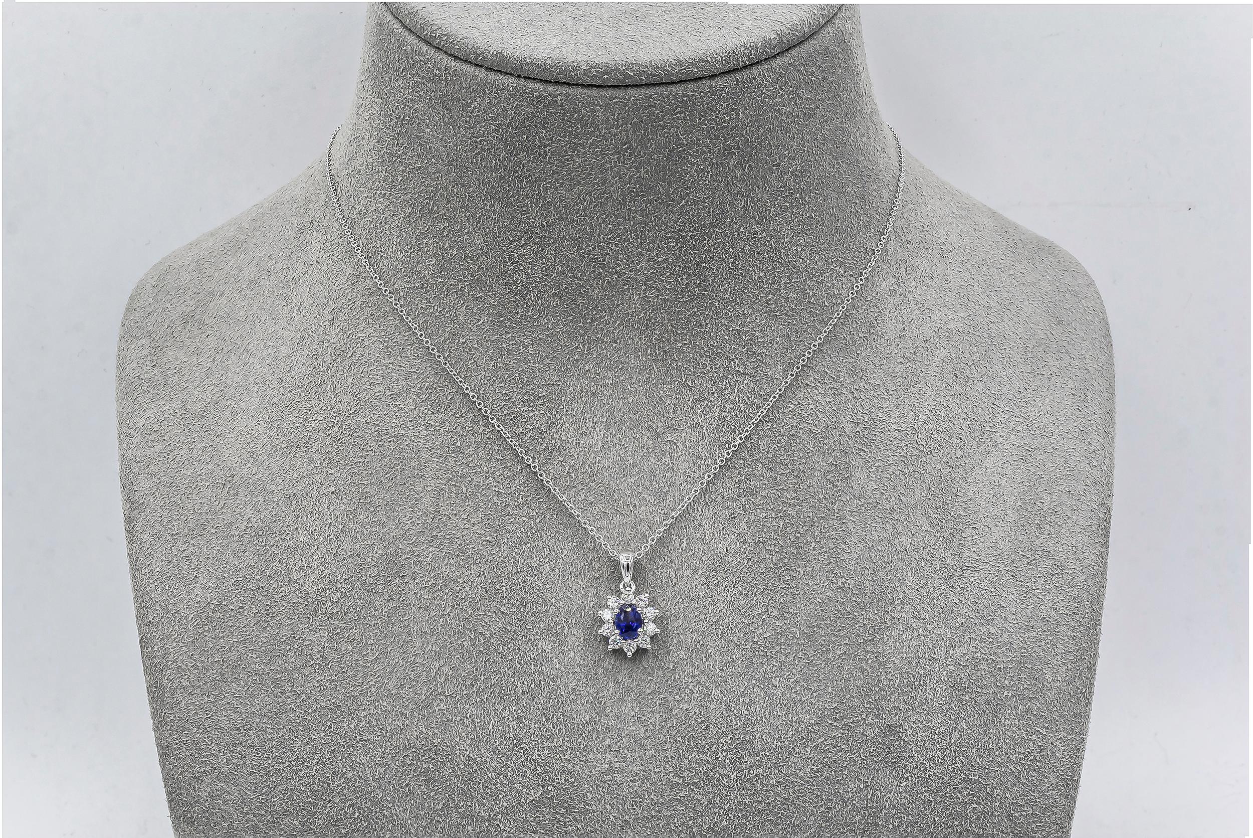A classic pendant necklace, featuring a 0.51 carat oval cut sapphire, set on a four prong setting. Accented by a halo of round cut diamonds weighing 0.27 carat total, set in a floral motif. Finely made with 18K white gold. 

Roman Malakov is a